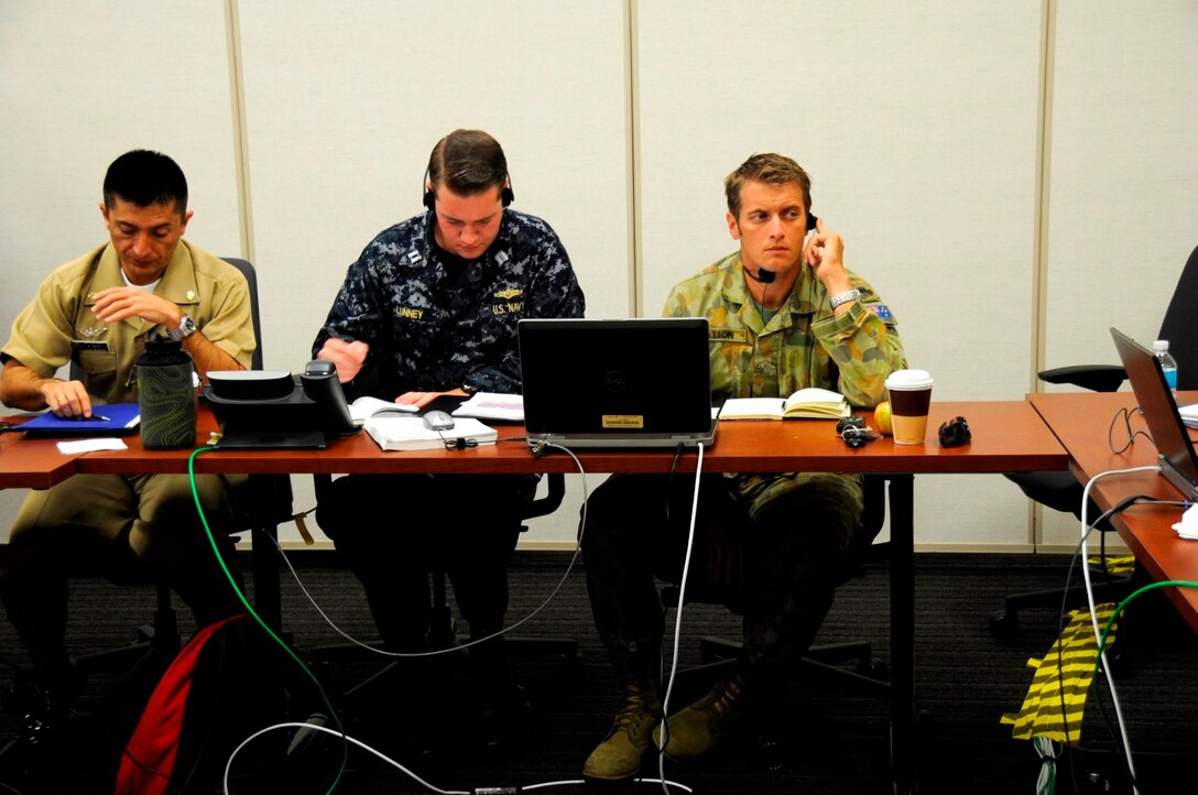 Australian Army Maj. Benjamin Watson, the assistant operations officer from the U.S. Marine Corps 15th Marine Expeditionary Unit, listens, through interpreter services, to an fellow PANAMAX 2013 participant during a discussion about defense strategies, August 15. Watson is participating in PANAMAX as a member of the Coalition Forces Maritime Component Command Cell. PANAMAX 2013 is an annual U.S. Southern Command-sponsored exercise series that focuses on ensuring the defense of the Panama Canal. PANAMAX 2013 develops and sustains relationships that improve the capacity of our emerging and enduring partners' security forces to achieve common desired goals, while fostering friendly cooperation and understanding among participating forces. PANAMAX 2013 is a multinational exercise that, this year, includes participants from Argentina, Belize, Brazil, Canada, Chile, Colombia, Costa Rica, Dominican Republic, Ecuador, El Salvador, France, Guatemala, Honduras, Mexico, Nicaragua, Panama, Paraguay, Peru, and the United States. (Official Marine Corps photo by SSgt. Earnest J. Barnes)