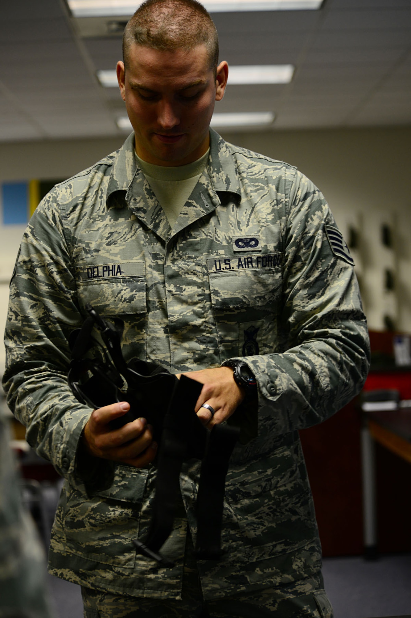 Staff Sgt. William Delphia inspects an M-9 berretta holster before the firing portion of class  Aug. 13, 2013, at Langley Air Force Base, Va. The CATM classes are broken down into a class portion in the morning, and a firing portion in the afternoon. Delphia is a 633rd Security Forces Squadron combat arms training and maintenance instructor.