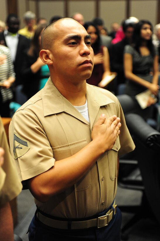 Lance Cpl. Edgar Raul Torres-Roman places his hand over his heart during his citizenship ceremony, to signify his devotion to his new country at the Kansas City Courthouse, Aug. 22. Torres-Roman is an administrative clerk with the 9th Marine Corps District and has been in the Marine Corps for one year.