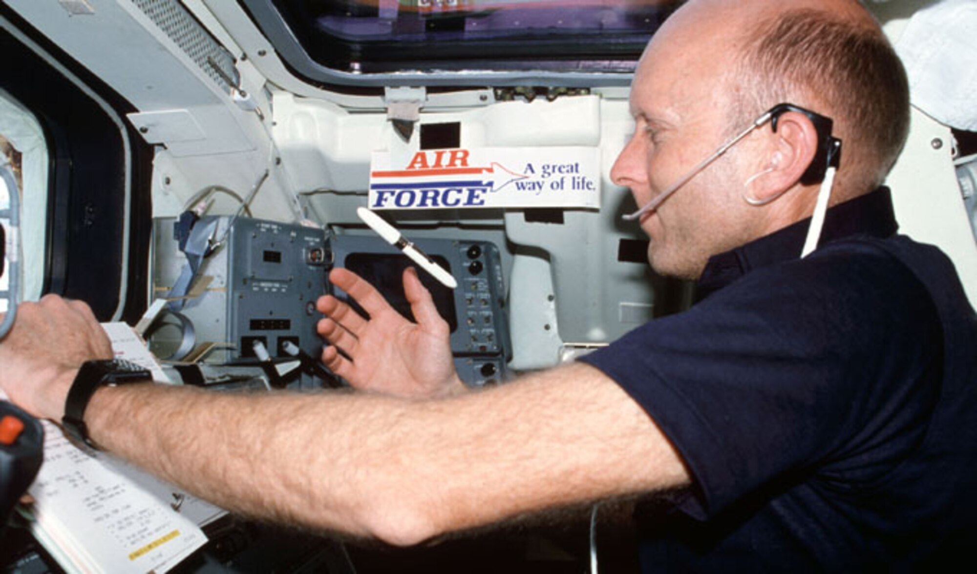 NASA astronaut and former Air Force test pilot, retired Col. Gordon Fullerton, wearing communications kit assembly (assy) mini headset, watches freefloating pen during checklist procedures on the aft-deck of Space Shuttle Columbia during the third shuttle mission, STS-3, in 1982. Fulerton's decal sticker "United States Air Force - a Great Way of Life" be seen overhead. (NASA photo)