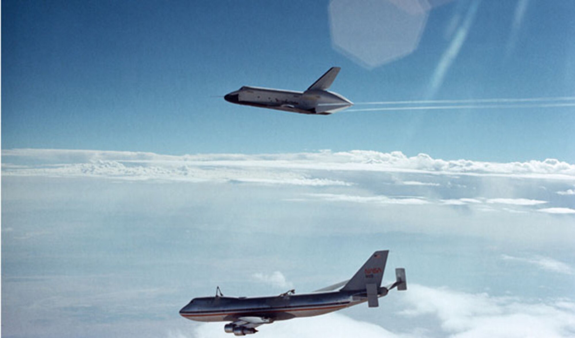 Space Shuttle Enterprise, with Fullerton and astronaut Fred Haise on board, soars above the NASA 747 carrier aircraft during the first free flight of the shuttle approach and landing tests at NASA Dryden Flight Research Center, Calif., in Aug. 1977. (NASA photo)