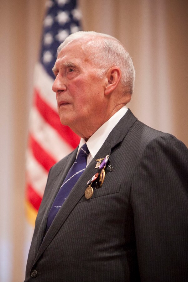 Ernest C. Brace stands during a ceremony where he received the Purple Heart and Prisoner-of-War Medals at Kingsley Air Force Base here, Aug. 16, 2013. Brace, a Marine in the Korean War era, was awarded the medals for his time as the longest-held civilian POW in the Vietnam War. 