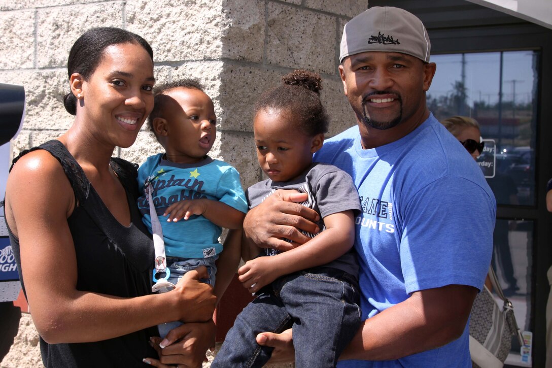 Former Chargers fullback, Lorenzo Neal, poses with Kiki Leasau and her sons, Camden and Christopher, at the Beverages Etc in Pacific Plaza here Aug. 22.  Neal met with fans, signed autographs and gave away free Chargers merchandise. Fans were also given an opportunity to enter a raffle for more free gifts.
