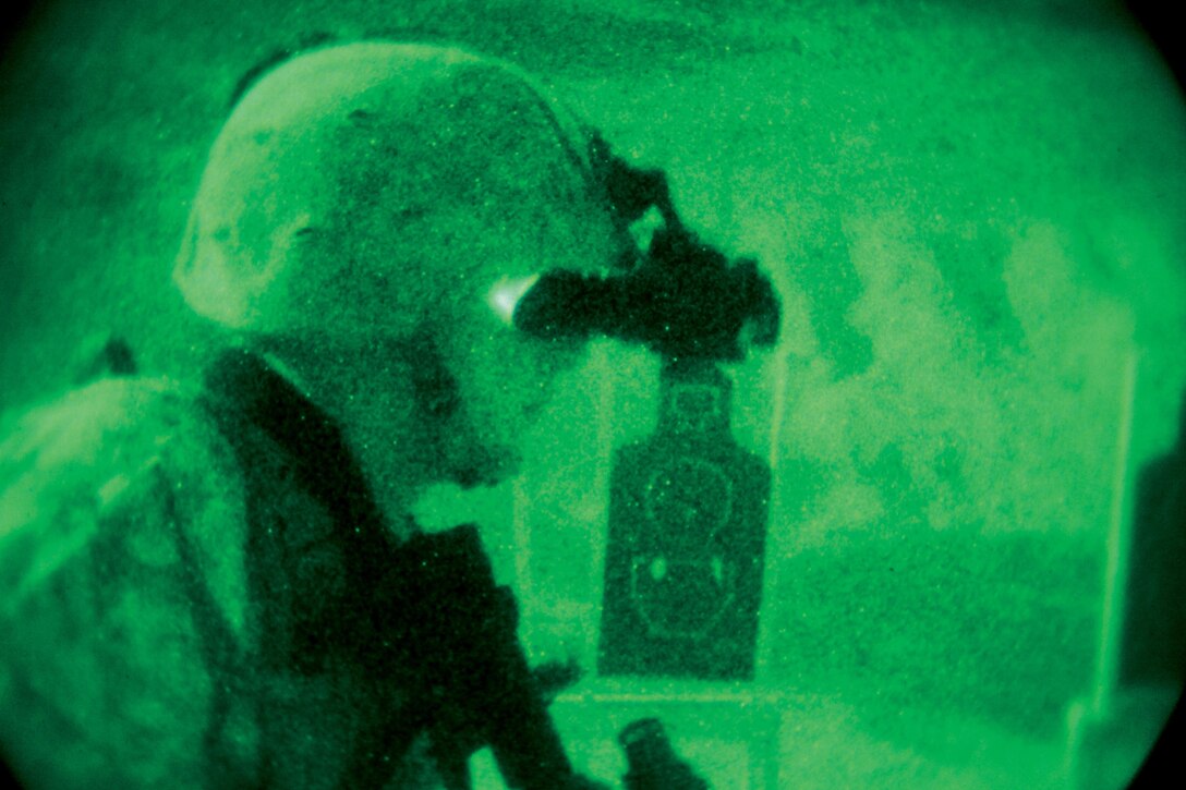 Cpl. Jacob W. Wroughton peers through his night vision goggle as he prepares to fire his M16A4 service rifle with an advanced target pointer illuminator during an intermediate combat rifle marksmanship course of fire Aug. 13 at Range 13 near Camp Schwab. Throughout the evening, the Marines built their confidence in the weapons system by practicing various combat shooting drills, according to Gunnery Sgt. David C. Peel, the staff noncommissioned officer in charge of support platoon and motor transport maintenance chief with 3rd Maintenance Bn., CLR-35, 3rd MLG, III MEF. Wroughton is an optics technician with the unit. Photo by Lance Cpl. Anne K. Henry