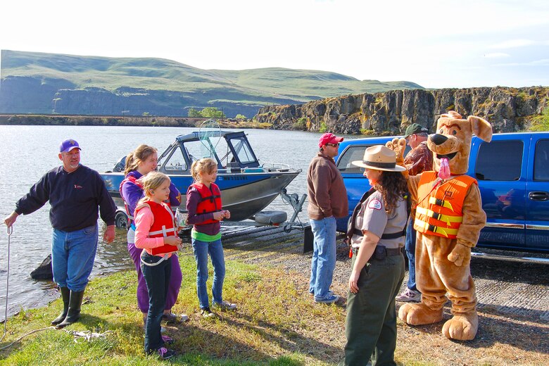 If you were visiting The Dalles in late April of 2013, you might have seen Bobber the Water Safety Dog while on his road trip with park ranger Amber Tilton, Kelly Thomas and David Ladouceur from The Dalles Lock and Dam.  

The day-long tour included a stop at Columbia Hills State Park to promote water safety in the Gorge and perform free boater safety checks in partnership with rangers from Washington State Parks and Washington Department of Fish and Wildlife.  They also visited Spearfish Lake and met with families who were there for the lakes’ opening fishing celebration … those casting for trout received bobbers and kids were given coloring books to help remind them to stay afloat by wearing a properly-fitted life jacket.  

Bobber the Water Safety Dog and his entourage ended their water safety adventures at the annual Cherry Fest where Bobber fitted life jackets and demonstrated how to be a “Smart Thinker – Not a Sinker” by wearing a life jacket.