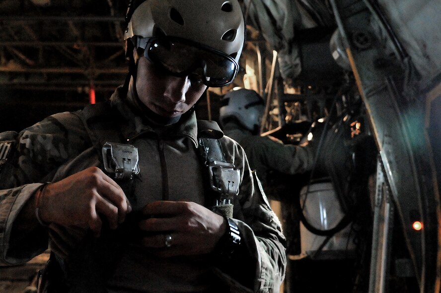 A U.S. Army jumpmaster dons his gear aboard a 374th Airlift Wing C-130 Hercules in preparation for joint jump training at Yokota Air Base, Japan, Aug. 21, 2013.  Jumpmasters are responsible for ensuring the jumpers land accurately on the drop zone.  (U.S. Air Force photo by Airman 1st Class Soo C. Kim)