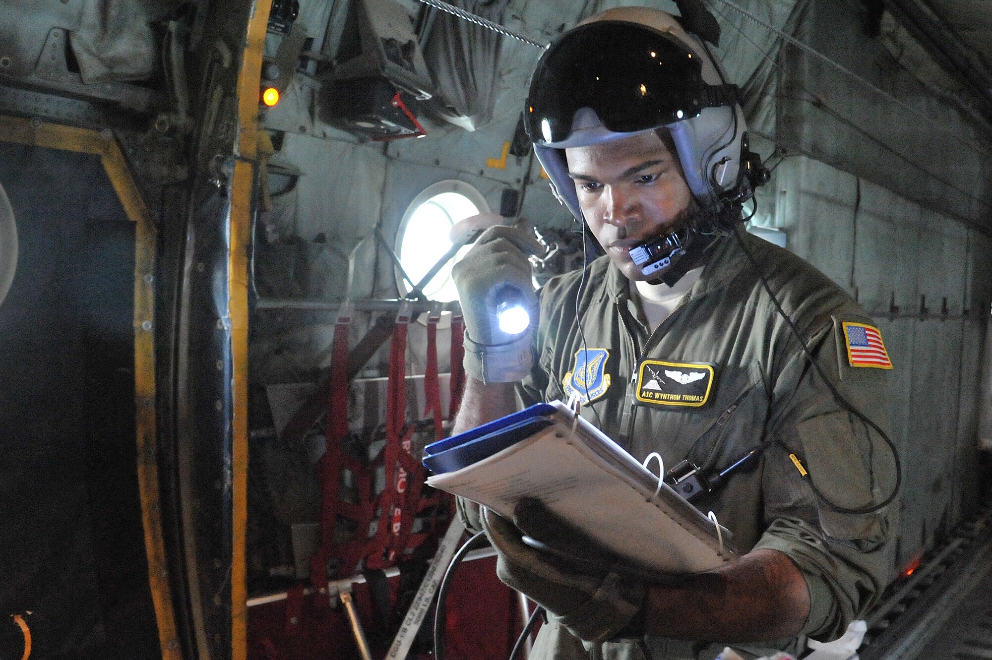Airman 1st Class Wynthom Thomas, 36th Airlift Squadron loadmaster, looks over a checklist during joint jump training at Yokota Air Base, Japan, Aug. 21, 2013.  The training provided an opportunity for both Airmen and Soldiers to improve their interoperability.  (U.S. Air Force photo by Airman 1st Class Soo C. Kim)