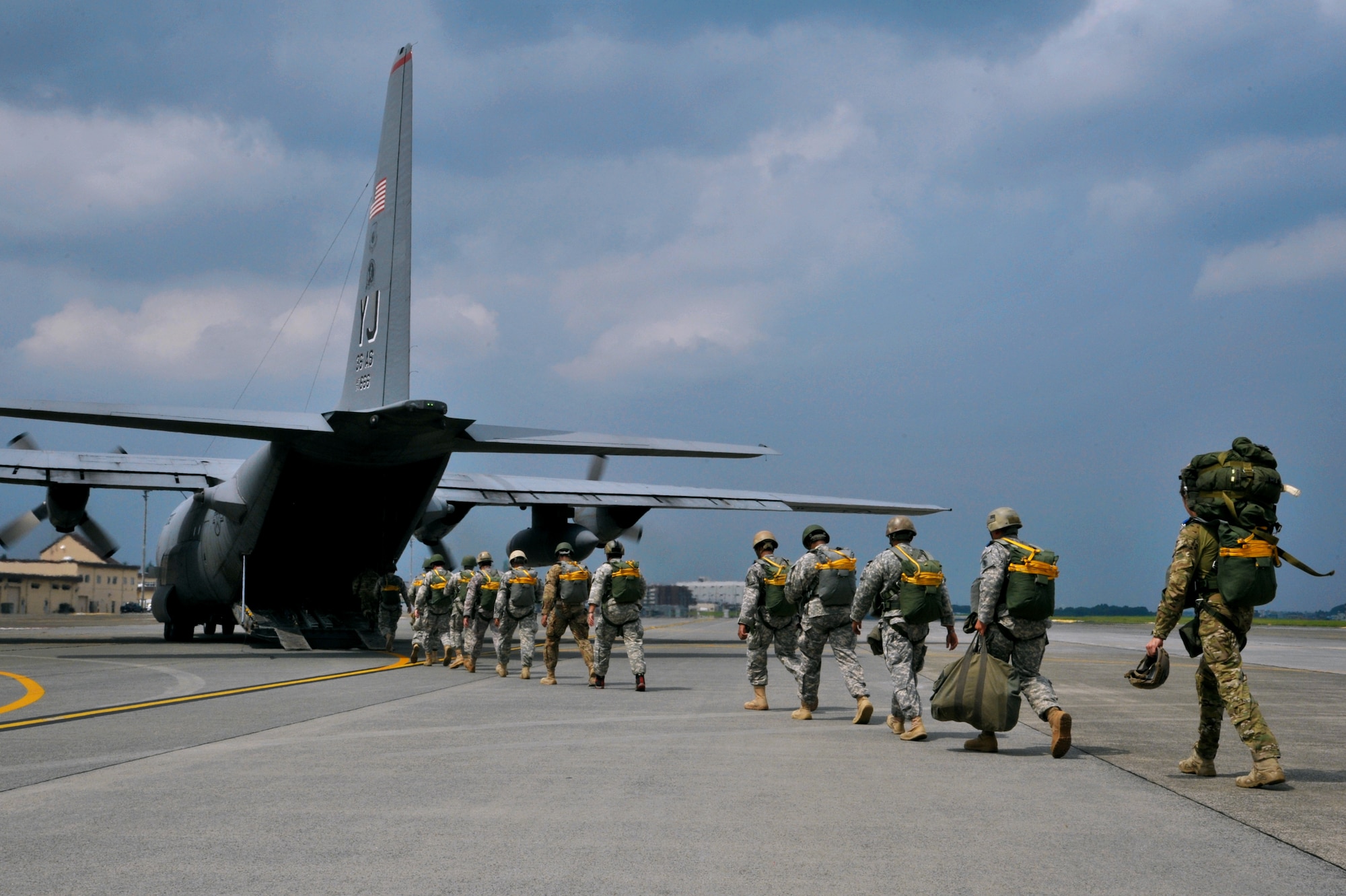 Soldiers make their way into a C-130 Hercules for joint jump training at Yokota Air Base, Japan, Aug. 21, 2013.  Three C-130s took flight for combat mass attack operations, providing an opportunity for both Airmen and Soldiers to improve their interoperability.  (U.S. Air Force photo by Airman 1st Class Soo C. Kim)