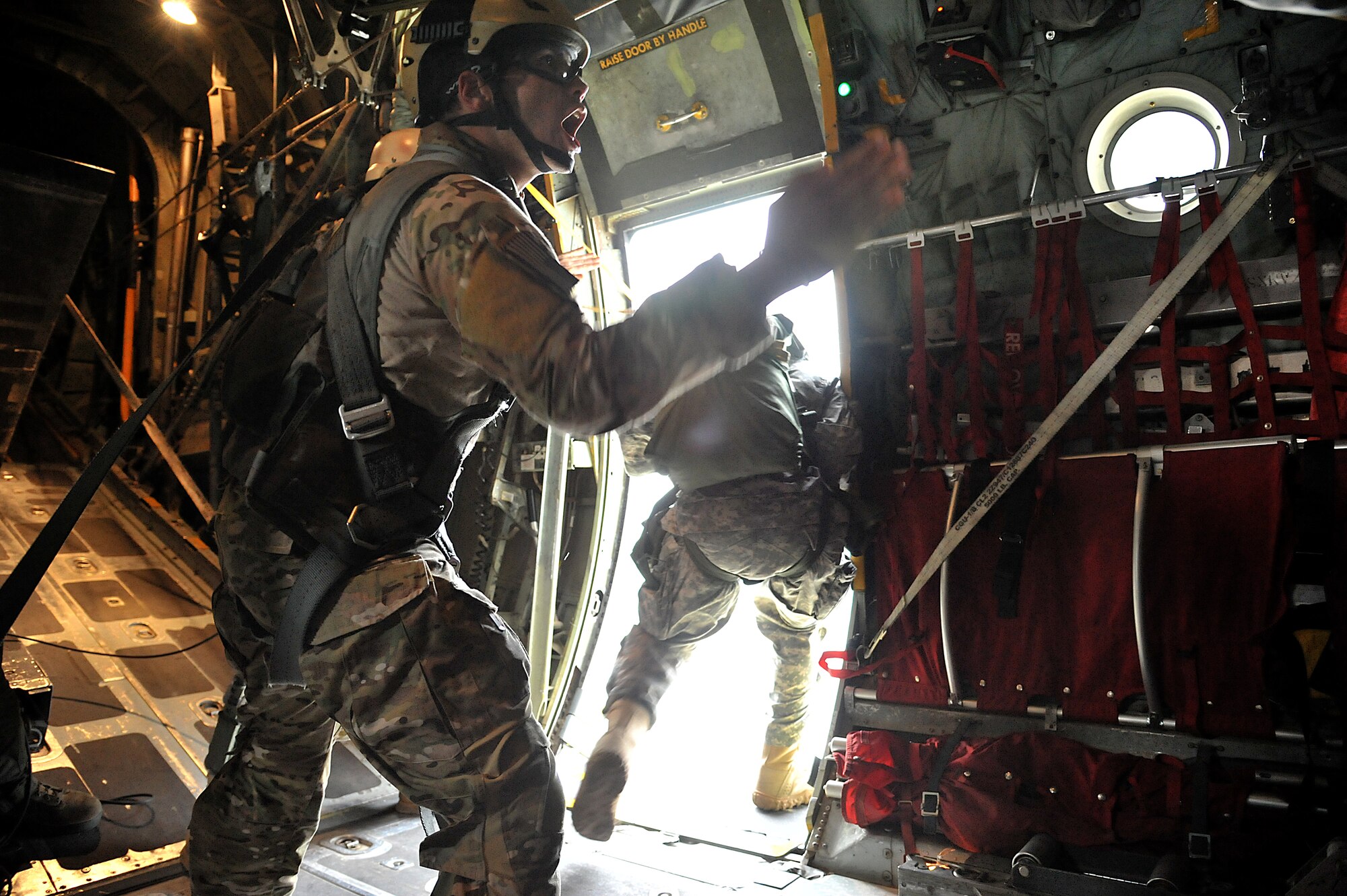 A U.S. Army jumpmaster directs paratroopers during joint jump training at Yokota Air Base, Japan, Aug. 21, 2013.  The training was necessary for maintaining the paratroopers’ proficiency.  (U.S. Air Force photo by Airman 1st Class Soo C. Kim)