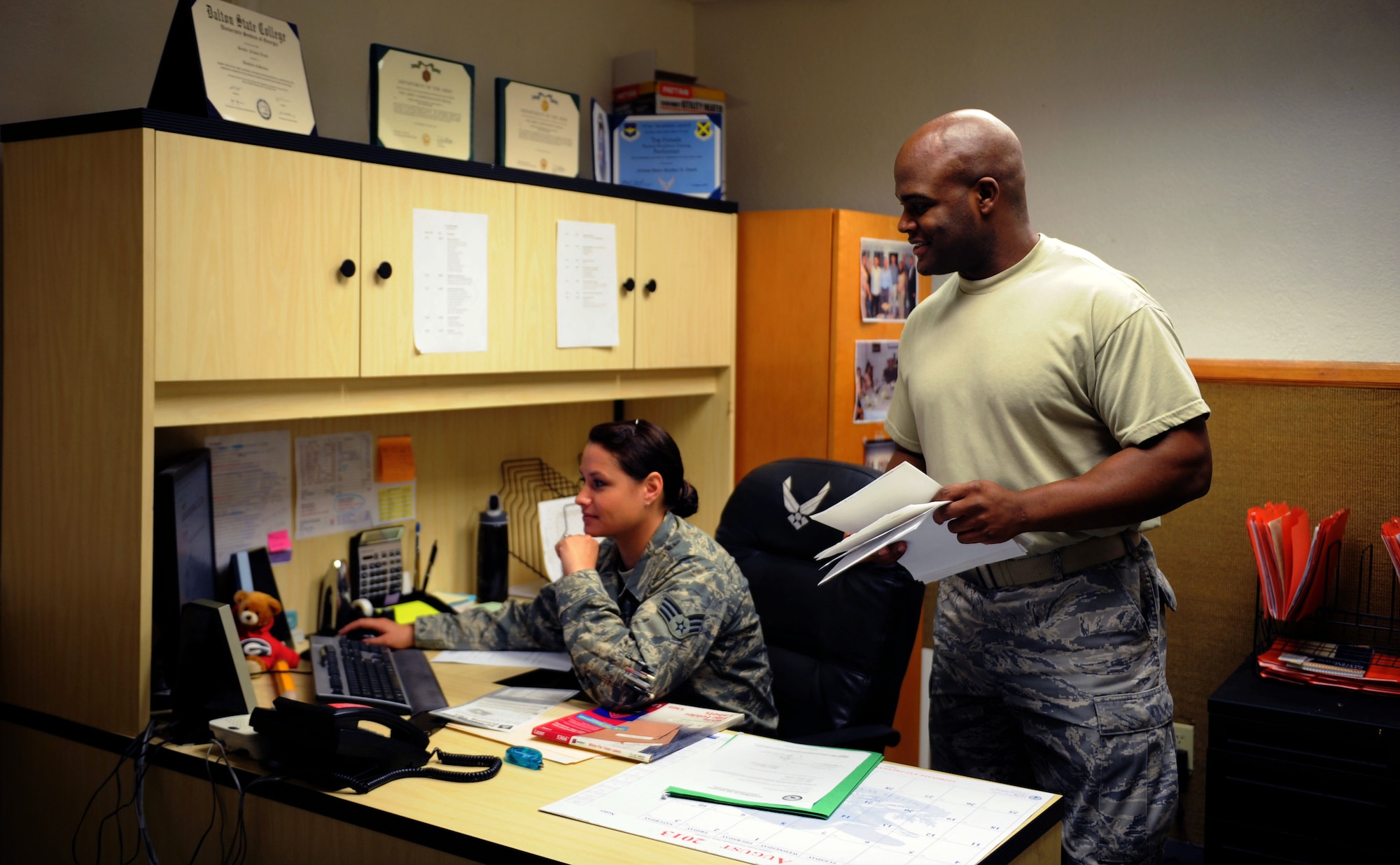 U.S. Air Force Staff Sgt. Brent Brooks, 355th Civil Engineer Squadron purchasing agent, looks on as Senior Airman Heather Truitt-Mata, 355th CES purchasing agent, goes over bank account information for the squadron's purchasing account. As purchasing agents, these Airmen are responsible for ordering maintenance materials for the 355th CES. (U.S. Air Force photo by Airman 1st Class Saphfire Cook/Released)