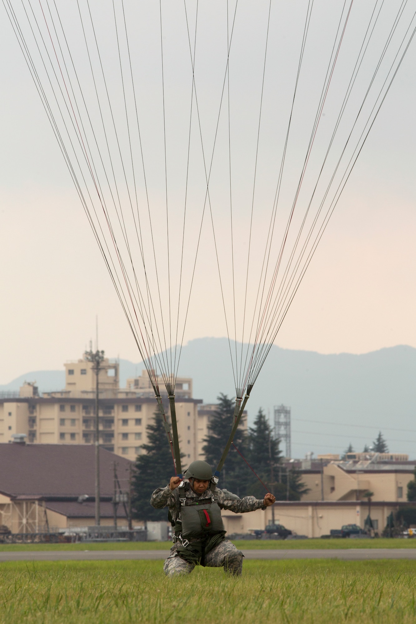 YOKOTA AIR BASE, Japan -- A U.S. soldier lands on a drop zone at Yokota Air Base, Japan, Aug. 22, 2013. Soldiers and Airmen conducted combined airborne jump training. (U.S. Air Force photo by Osakabe Yasuo)