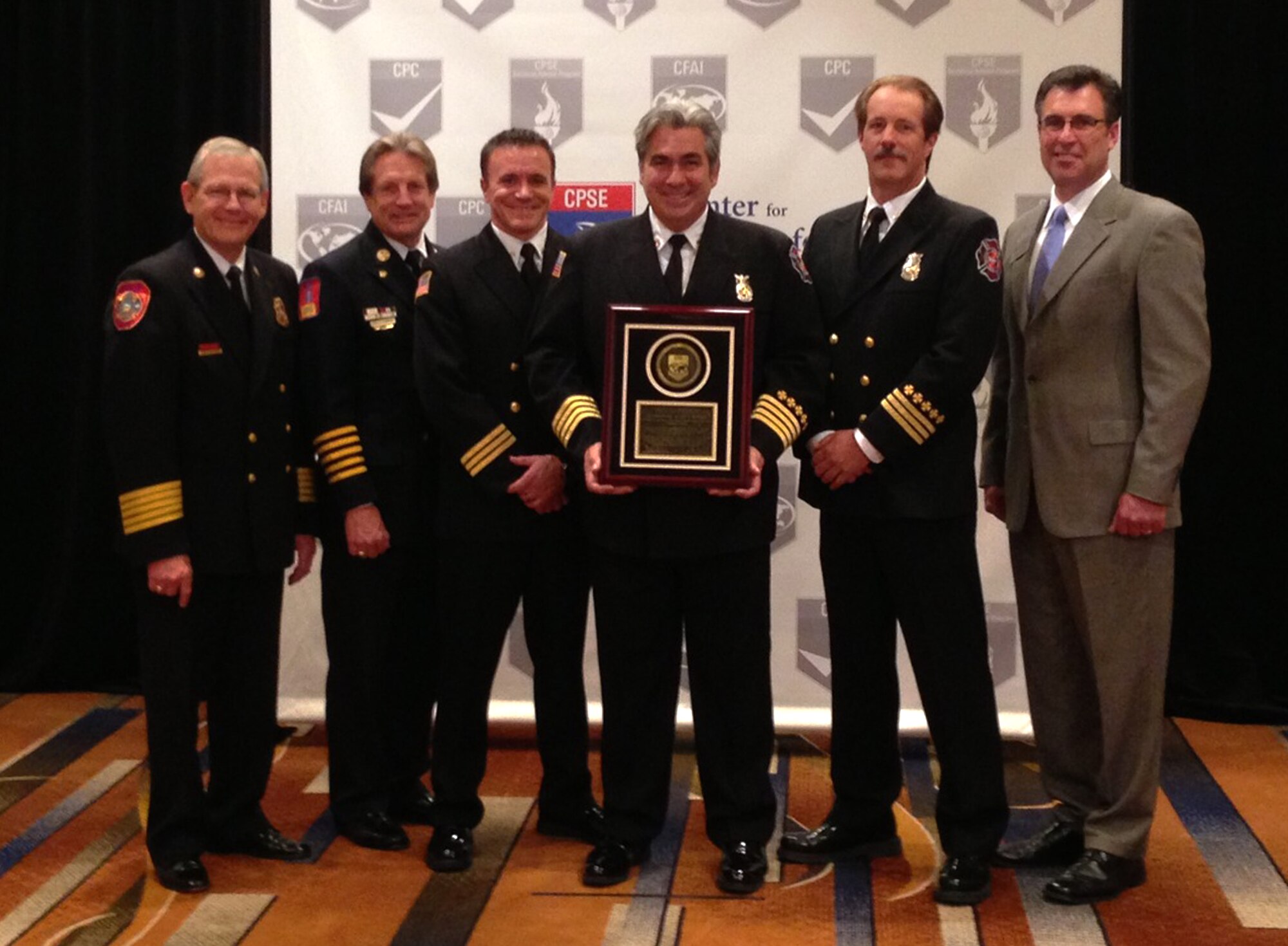 Buckley Fire and Emergency Services members receive an accredited agency plaque from Commission on Fire Accreditation International members Aug. 15, 2013, in Chicago. The department is one of only 150 international agencies and eight Air Force installations to achieve the accredited agency status with the CFAI and the Center for Public Safety Excellence. (Courtesy Photo) 