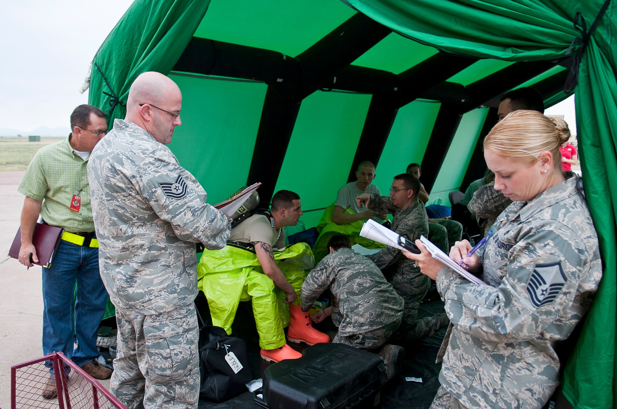 ALTUS AIR FORCE BASE, Okla. – Inspectors from the Air Education and Training Command  consolidated unit inspection team, observe as members of the 97th Civil Engineer Squadron emergency management flight respond to an unknown substance during an exercise, Aug. 14. The exercise allowed the CUI team to inspect the entire emergency management process to ensure that responders skills and training meet or exceed Air Force regulations. (U.S. Air Force photo by Senior Airman Dillon Davis/Released)