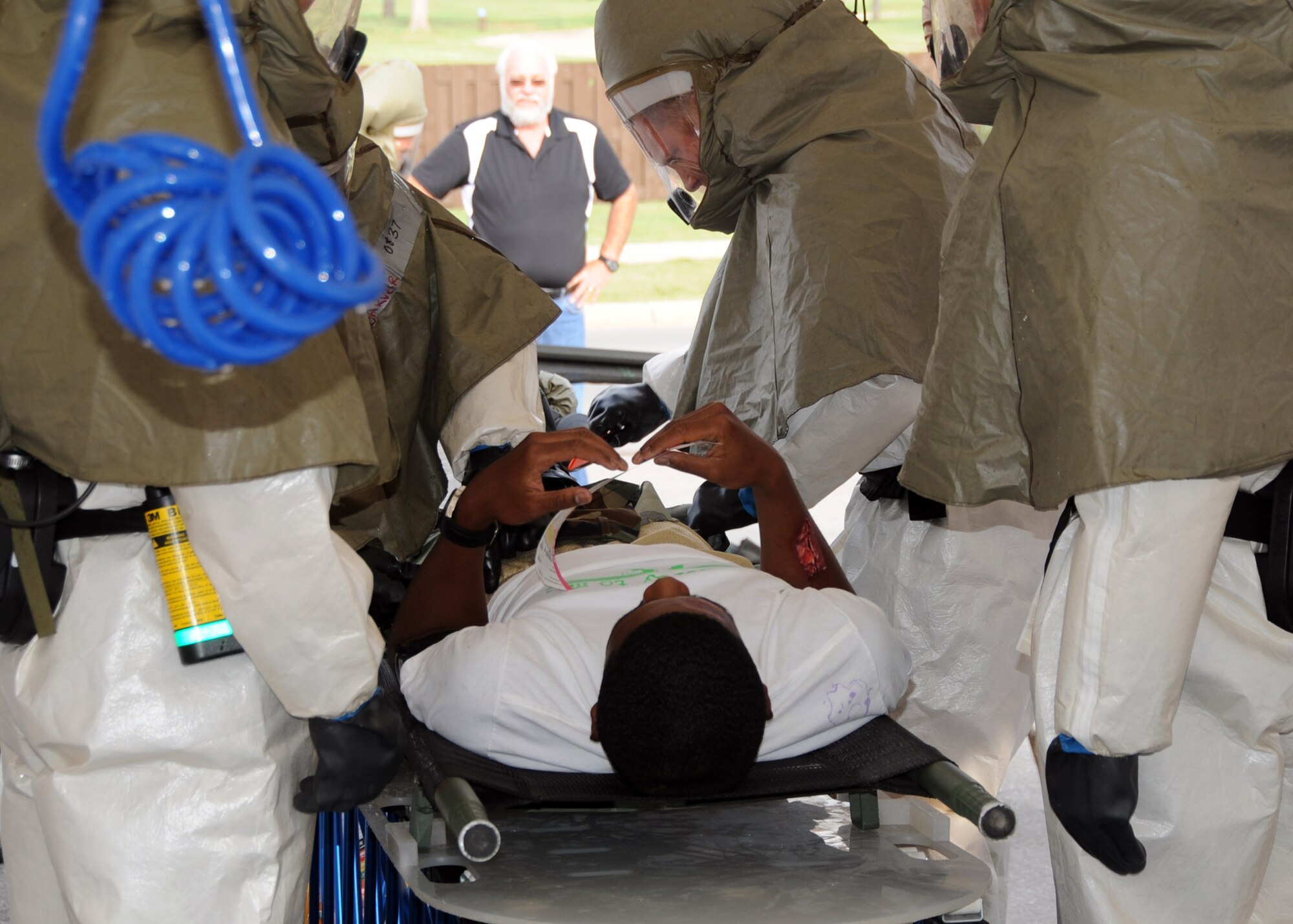 ALTUS AIR FORCE BASE, Okla. – U.S. Air Force members assigned to the 97th Medical Group, remove clothing from an individual during an exercise held at the 97th MDG as part of the Consolidated Unit Inspection, Aug. 14. The 97th MDG conducted a CUI task evaluation exercise on Chemical, Biological, Radiological, Nuclear and high yield Explosives.  Inspectors from Air Education and Training Command visited and assessed various units and the base as a whole Aug. 12-15. Results of the inspection are scheduled to be announced Aug. 21. (U.S. Air Force photo by Airman 1st Class Franklin R. Ramos / Released)