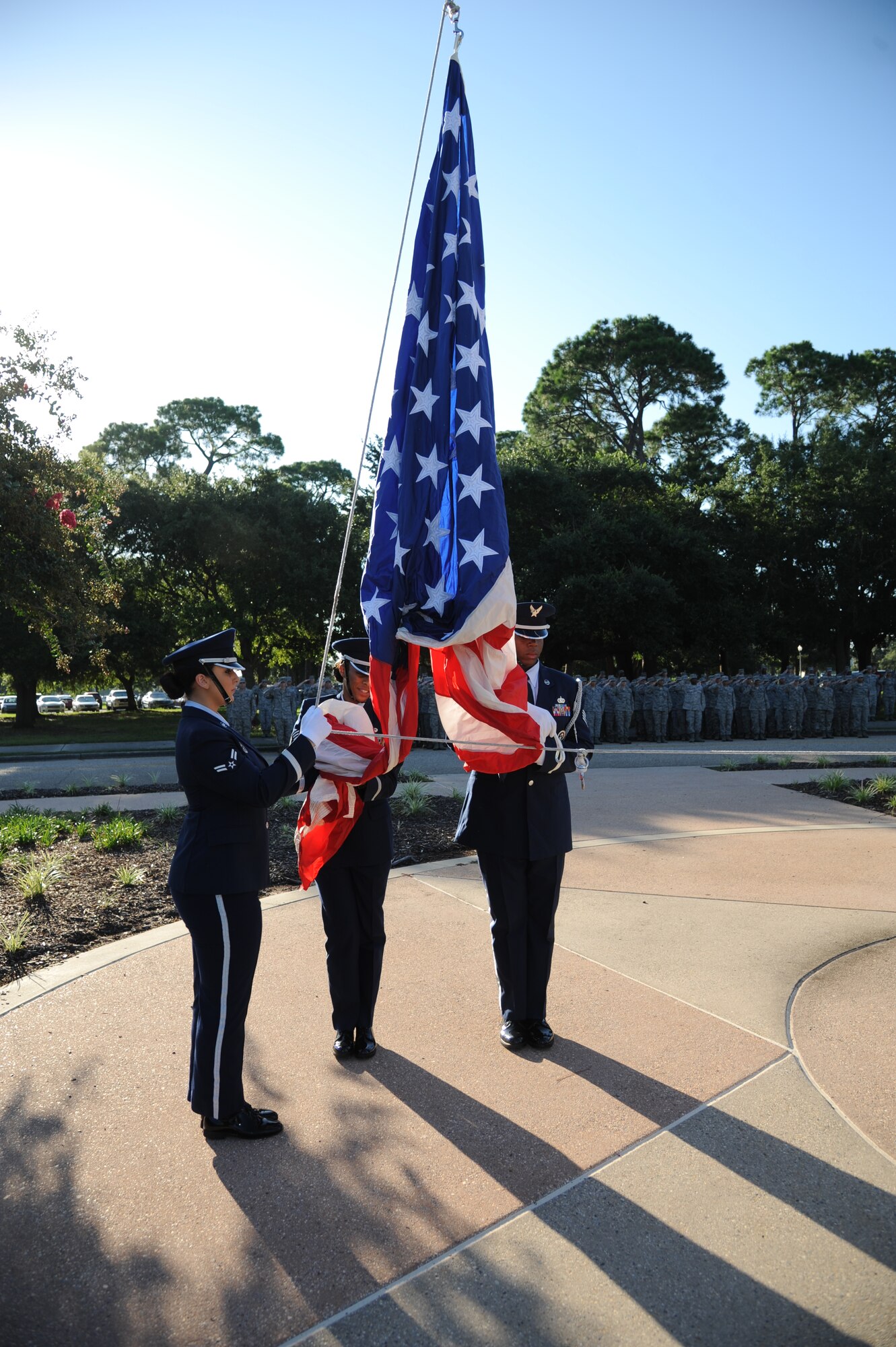 Airman 1st Class Carly Cervantes, Tech. Sgt. Kimberly Williams-Mason and Staff Sgt. Vernon Peoples, Keesler Honor Guard, prepare to raise the American flag and the Commander-in-Chief’s Installation Excellence award flag in front of the 81st Training Wing headquarters building Aug. 22, 2013, at Keesler Air Force Base, Miss.  Keesler was presented the award in April, 2013. (U.S. Air Force photo by Kemberly Groue)