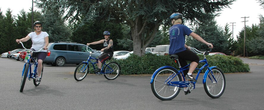 Senior Master Sgt. Liz Milligan (left to right), Senior Airman Laura Olson, and Staff Sgt. Tara Lamson start out on a lunch time ride using bikes from the McChord Blue Bike program. Milligan, Olson and Lamson are with the 446th Operations Support Flight.  (U.S. Air Force Reserve photo by Sandra Pishner)