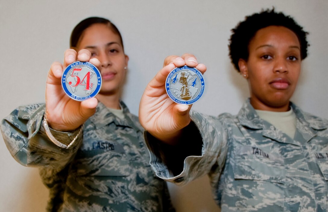 Master Sgt. Nora Castro and Tech. Sgt. Carolyn Tatum, 136th Airlift Wing, Texas Air National Guard, show off the coin they received from Lt. Gen. Stanley Clarke during his site visit at Naval Air Station Fort Worth Joint Reserve Base, Aug. 21, 2013. Lt. Gen. Clarke awarded the coins for serving with distinction. . (Air National Guard photo by Airman Cody Witsaman/released)