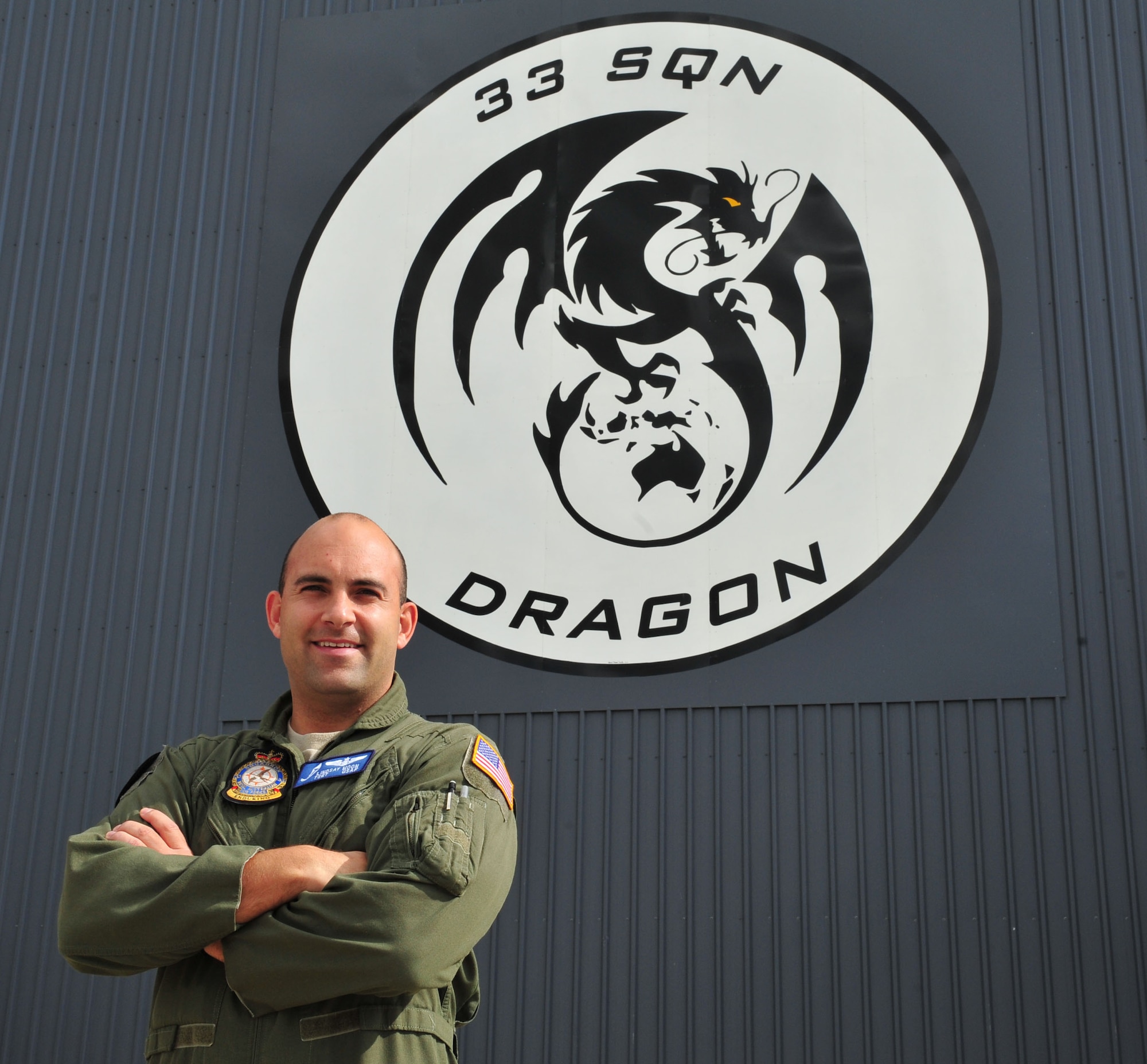 U.S. Air Force Tech. Sgt. Lindsay Moon, an aerial refueling operator assigned to No. 33 Squadron, Royal Australian Air Force Base Amberley, poses for a photo outside of his squadron, RAAF Amberley, Australia, July 26, 2013. Moon, assigned to RAAF as part of an exchange program, wears an American flight suit with the U.S. Flag patch on the left shoulder, but wears RAAF Squadron and MAJCOM equivalent patches. (U.S. Air Force photo by Staff Sgt. Rachelle Coleman)