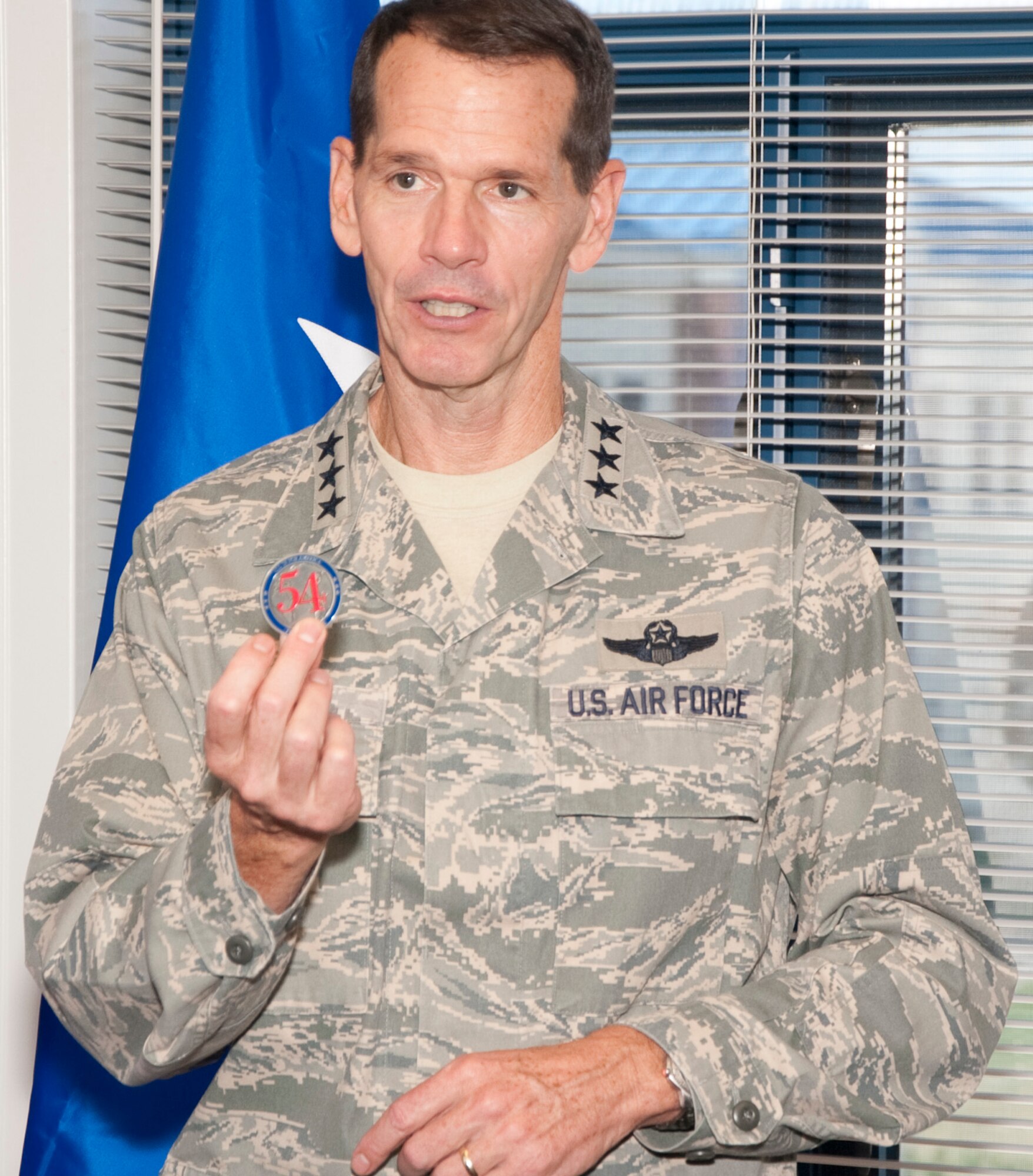Lt. Gen. Stanley Clarke, director, Air National Guard show off his coin prior to rewarding the Airmen of the 136th Airlift Wing, Texas Air National Guard for serving with distinction at Naval Air Station Fort Worth Joint Reserve Base, Aug. 21, 2013 during his site visit. The number 54 signifies 50 States, three territories and one District. (Air National Guard photo by Airman Cody Witsaman/released)