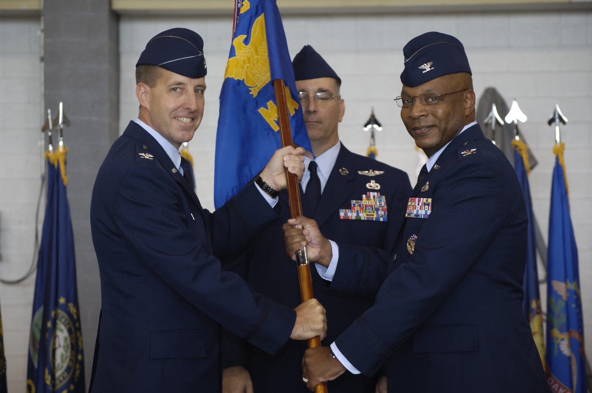Col. André L. Kennedy, right, accepts command of the 552nd Maintenance Group from 552nd Air Control Wing Commander Col. Jay Bickley during an Aug. 13 ceremony. Colonel Kennedy replaces Col. Stella Smith, who retired after a 24-year Air Force career. (Air Force photo by Darren D. Heusel)