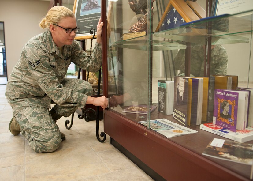 U.S. Air Force Airman 1st Class Emily Powell, 23d Force Support Squadron Military Personnel Services customer support representative, finishes arranging  a Women’s Equality Day display in the 23d Wing headquarters building at Moody Air Force Base, Ga., Aug. 19, 2013. Powell and Senior Master Sgt. Cheryl Moye, 23d FSS manpower and personnel flight chief, started Moody’s first Women’s Equality Day committee to recognize the historical accomplishments of women overcoming inequality. (U.S. Air Force photo by Senior Airman Eileen Meier/Released)