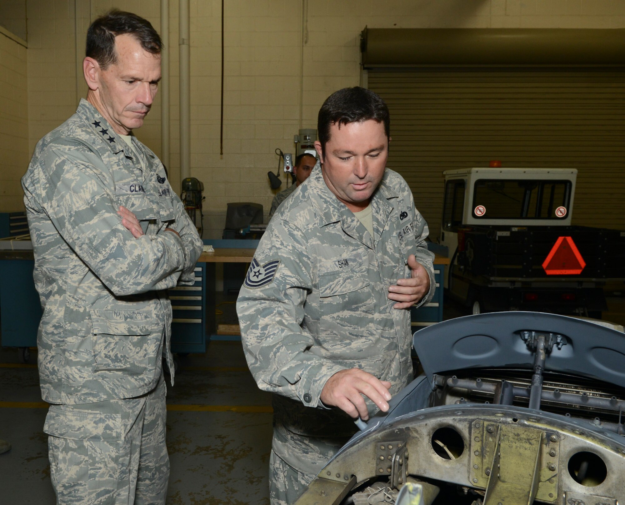 Lt. Gen. Stanley Clarke, director, Air National Guard, listens intently to Tech. Sgt. Jimmy Shaw, metals  fabrication technician, 136th Airlift Wing, Texas Air National Guard during his site visit at Naval Air Station Fort Worth Joint Reserve Base, Aug. 21, 2013. Shaw explains the process for repairing an engine cowling to Lt. Gen. Clarke. (Air National Guard photo by Senior Master Sgt. Elizabeth Gilbert/released)