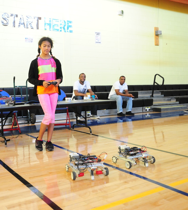 Lidia Mason, Youth Center member and daughter of Maj. Johnnie Mason, 844 Communications Group deputy of plans and programs, learns to operate remote cars with FIRST Robotics at the Back-to-School Bash on Aug. 15, 2013, held at the Youth Center on Joint Base Andrews, Md. The Military and Family Support Center sponsored the event to encourage students to engage in Science, Technology, Engineering, and Mathemetics, STEM. (U.S. Air Force photo/ Ms. Amber J. Russell)