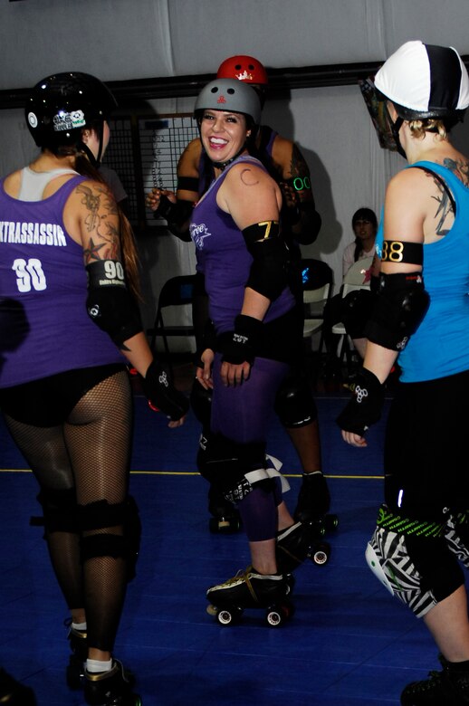 U.S. Air Force Staff Sgt. Hilary Middleton, 355th Operations Support Squadron aircrew flight equipment technician, laughs with teammates while preparing to start the All-Star Jamboree in Tucson, Ariz., August 10, 2013. Middleton has been a member of the Tucson Roller Derby since 2011. (U.S. Air Force photo by Airman 1st Class Betty R. Chevalier/Released)