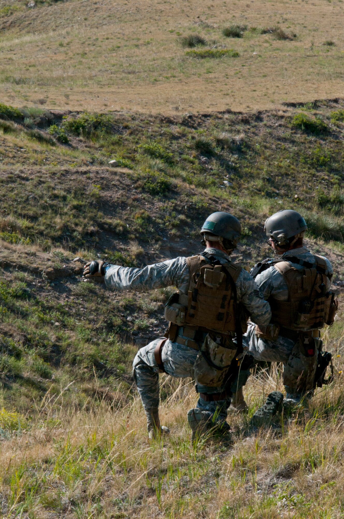 130814-F-BR137-199
Staff Sgt. Wade Ottman, 91st Security Forces Group Tactical Response force, and Senior Airman Gareck Esposito, 91st SFG TRF, plan their approach to the Tango-09 Launch Facility, a deactivated Peacekeeper ICBM launch facility, Aug. 14, 2013. TRF members, and helicopter pilots practiced recapturing the LF from opposing forces by using a combination of ground and air tactics. (U.S. Air Force photo by Airman 1st Class Jason Wiese)
