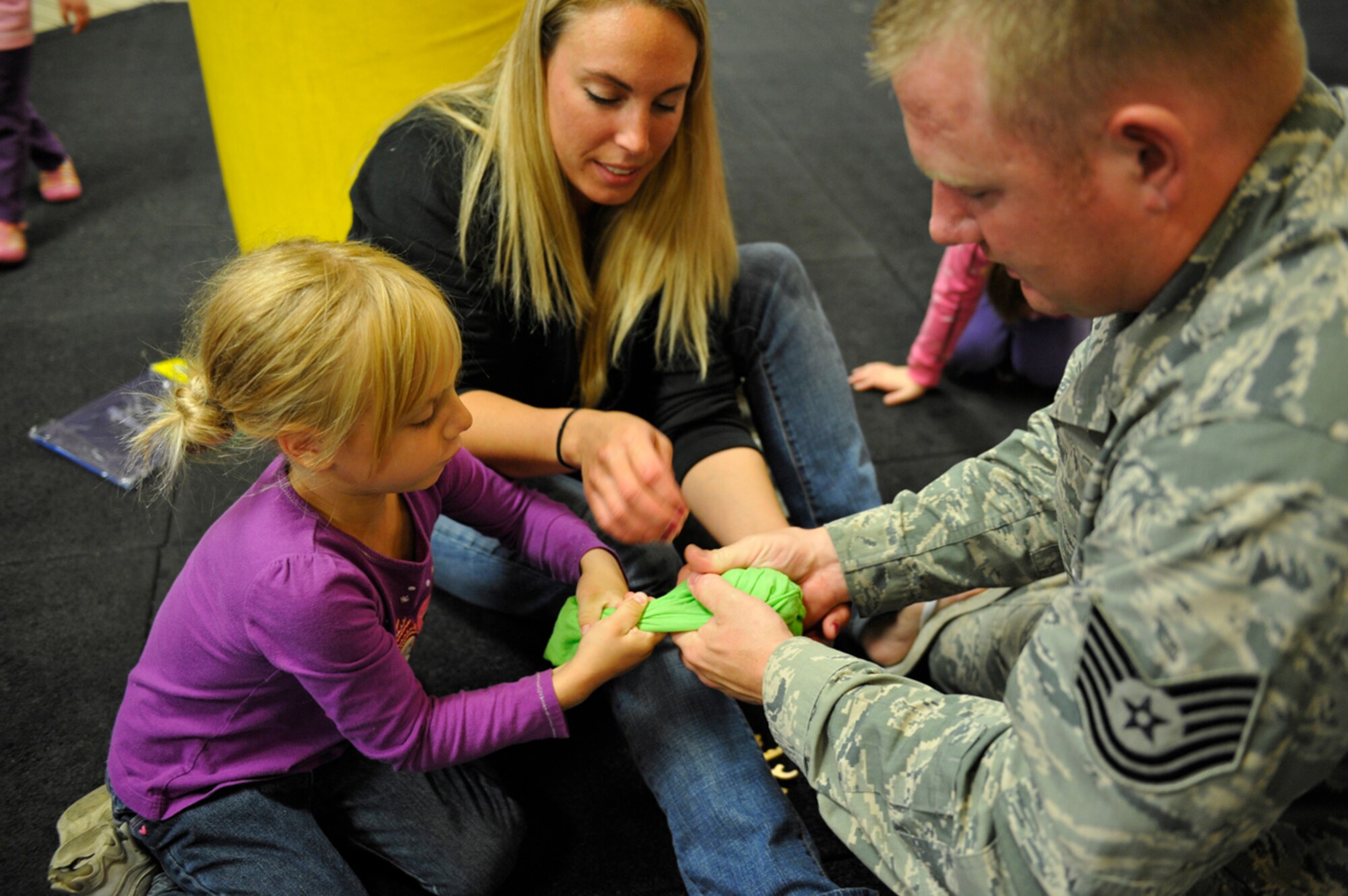 8/16/2013 - JOINT BASE ELMENDORF-RICHARDSON, Alaska--Air Force Tech. Sgt. Andrew Keeley, 715th Air Mobility Operations Group noncommission officer in charge of group commander's support staff, Air Force Staff Sgt. Kimberly Keeley, 477th Operations Support Flight Air Force Reserve Command, and Claire Keeley, their daughter, try to thaw a frozen T-shirt during the Back to School Bash on Joint Base Elmendorf-Richardson Aug. 16. The contest challenged children and their parents with the task of thawing a frozen T-shirt and putting it on the fastest. Claire Keeley finished the six and under group, with the help of her parents, in 30 minutes. (U.S. Air Force photo/Airman 1st Class Tammie Ramsouer)