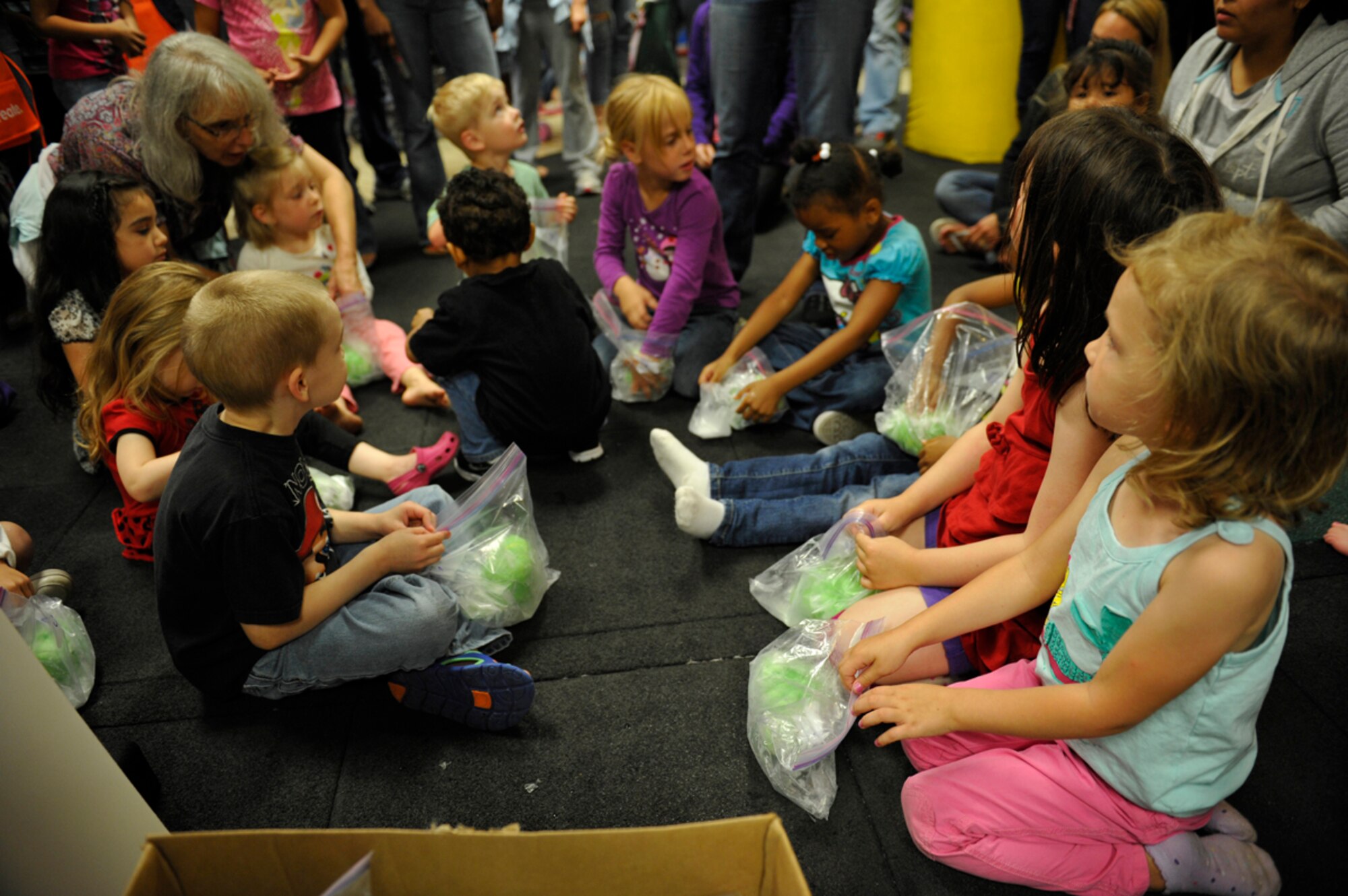 8/16/2013 - JOINT BASE ELMENDORF-RICHARDSON, Alaska--Children receive T-shirts during the frozen T-shirt contest during the Back to School Bash on Joint Base Elmendorf-Richardson Aug. 16. The contest challenged children to quickly thaw a frozen T-shirt with the help of their parents. (U.S. Air Force photo/Airman 1st Class Tammie Ramsouer)
