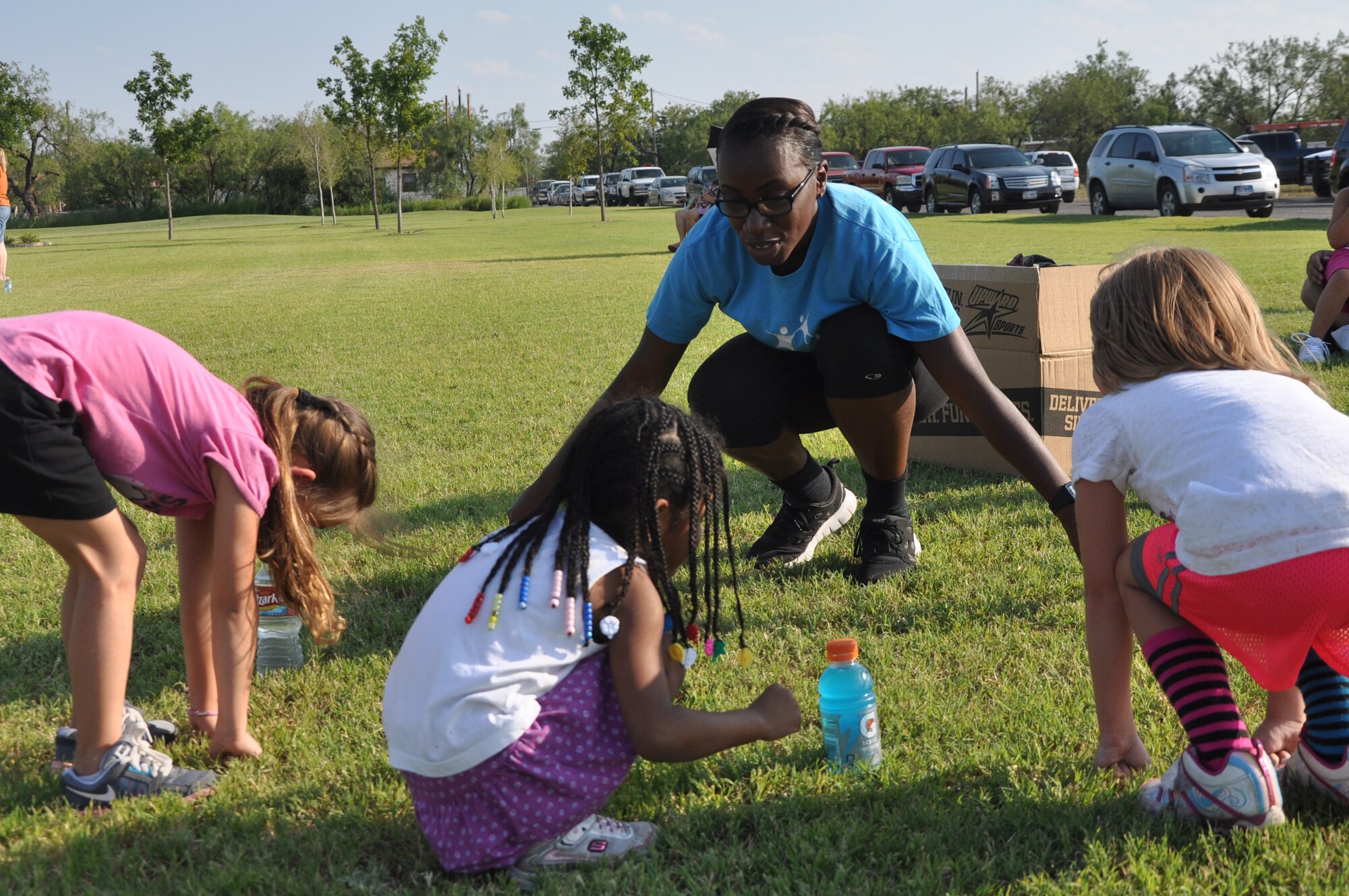 SAN ANGELO, Texas --  Airman 1st Class Kendra Norman, 17th Force Support Squadron command support staff, teaches her cheerleading squad how to do a “toe-touch” during practice at Producer’s Park Aug. 20. Norman has volunteered in programs such as Big Brother Big Sister and other youth coaching activities. (U.S. Air Force photo/ Airman 1st Class Breonna Veal)