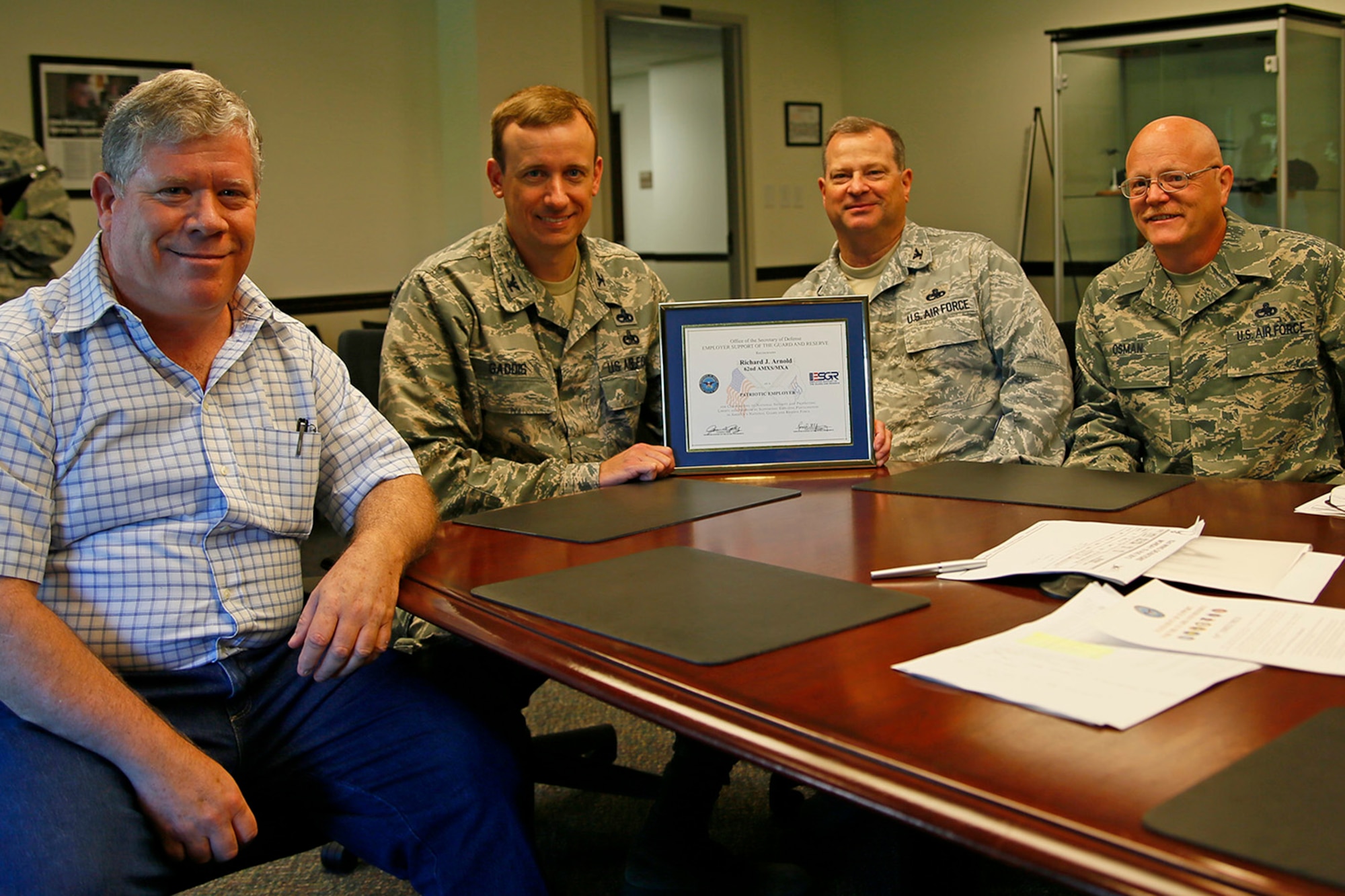 (From left to right) Mr. Rich Arnold, Col. Craig Gaddis, Col. Alan Lerner, and Master Sgt. Roy Osman display the Employer Support of Guard and Reserve Patriot Award in the 62nd Maintenance Group conference room, McChord Field, Wash., Aug. 20. Osman, plays a dual role within the 446th Maintenance Group and 62nd MXG. As a Citizen Airman, he is a C-17 Globemaster III aircraft maintenance technician. As a full-time Air Force civilian, he's a mechanic with the 62nd Aircraft Maintenance Squadron. Osman nominated his civilian supervisor, Arnold, for the Patriot Award for providing support for him while he was deployed for a year. Gaddis is the 62nd MXG commander and Lerner is the 446th MXG commander. (U.S. Air Force Reserve photo/Master Sgt. Jake Chappelle)