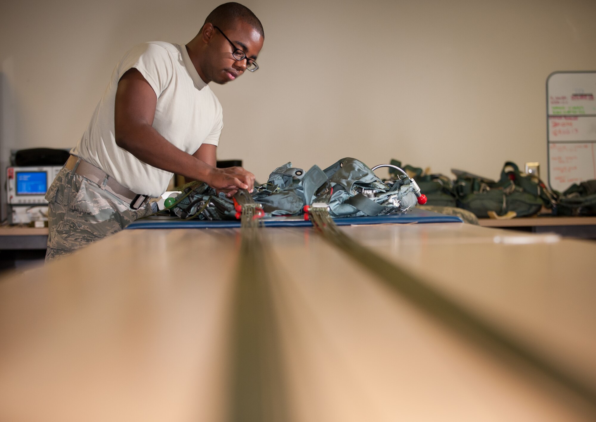 Senior Airman Kristofer Salaah, 305th Operations Support Squadron aircrew flight equipment journeyman, visually inspects and rigs the harness and pack assembly on a Back Automatic parachute Aug. 16, 2013, on Joint Base McGuire-Dix-Lakehurst, N.J. The mission of the 305th OSS is to provide information, support, and equipment to allow aircrews to accomplish their global mobility mission. (U.S. Air Force photo by Russ Meseroll/Released)