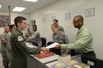Curlie Alexander (right), 902nd Logistics Readiness Squadron alternate installation deployment officer, assists Maj. Jason Kelly, 359th Aerospace Medial Squadron flight surgeon, Aug. 7 during the Joint Base San Antonio-Randolph readiness center deployment line. (U.S. Air Force photo by Joel Martinez)
