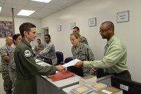 Curlie Alexander (right), 902nd Logistics Readiness Squadron alternate installation deployment officer, assists Maj. Jason Kelly, 359th Aerospace Medial Squadron flight surgeon, Aug. 7 during the Joint Base San Antonio-Randolph readiness center deployment line. (U.S. Air Force photo by Joel Martinez)
