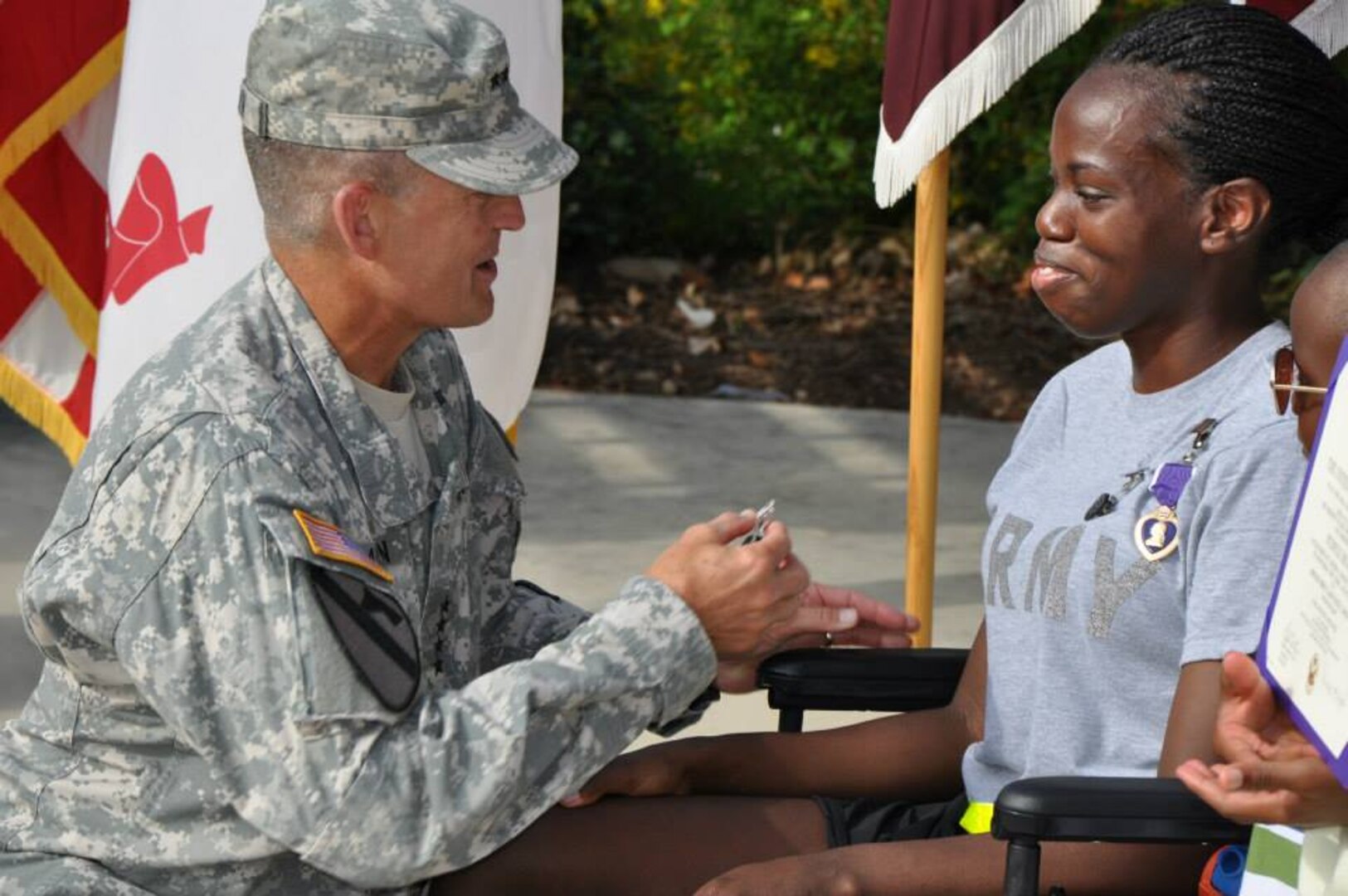 Gen. Daniel B. Allyn (left), commanding general of U.S. Army Forces Command, presents a Purple Heart medal to Pfc. Cicely Holmes during a ceremony at the Warrior and Family Support Center Aug. 13. She also received the Combat Medical Badge and Combat Action Badge. Holmes was injured July 23 while conducting a route clearance mission when her vehicle was struck by an improvised explosive device resulting in her combat injuries. Sgt. Stephen Jackel also received the Purple Heart. His vehicle struck an improvised explosive device while on patrol resulting in a double amputation while serving in Afghanistan in August 2011. (Photo by Robert Shields, Brooke Army Medical Center Public Affairs)