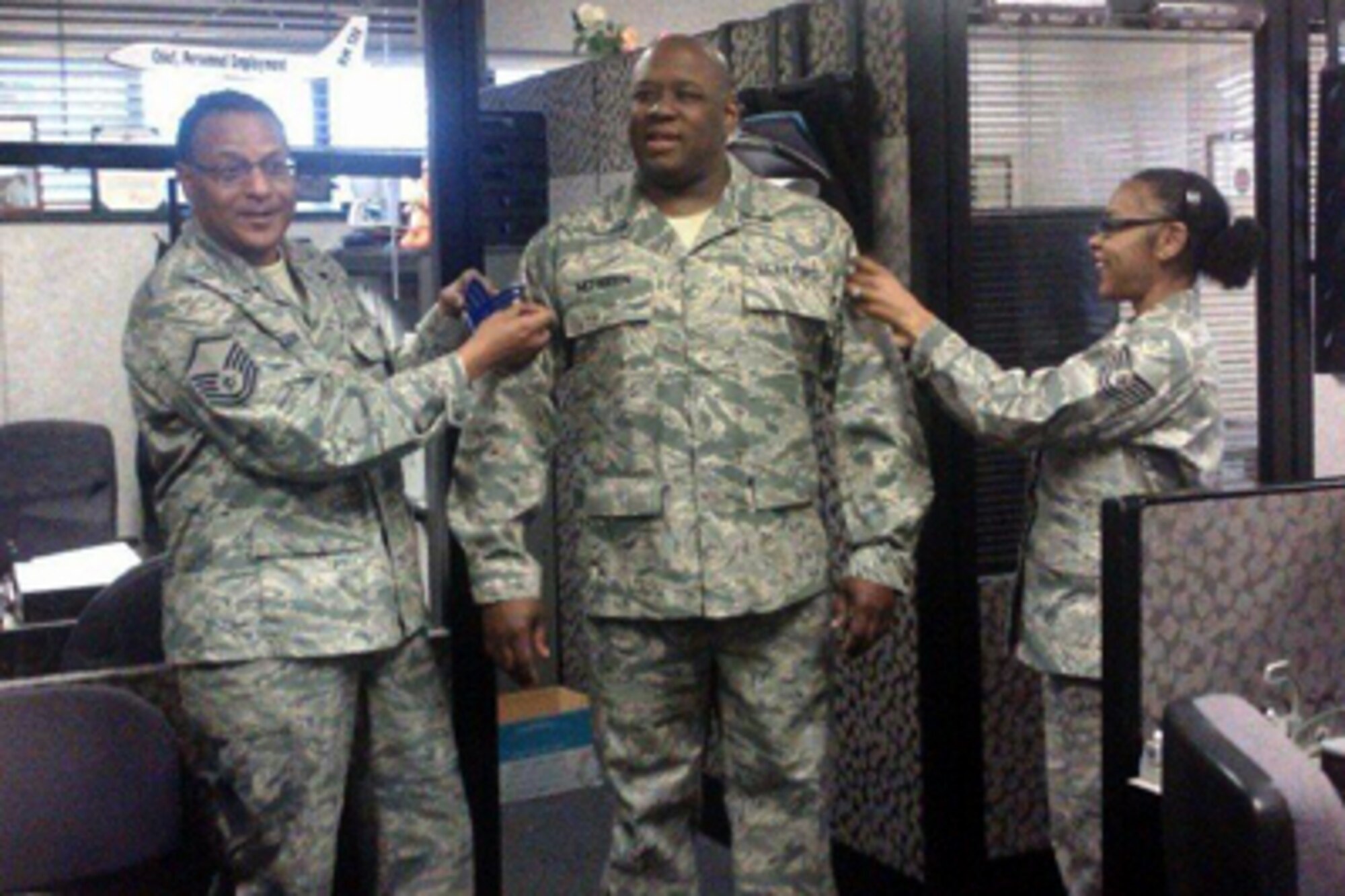 Staff Sgt. James McFadden, center, pins on his new rank as a personnel journeyman assigned to the 916th Force Support Squadron. McFadden recently returned from a deployment supporting the Air Expeditionary Force. (USAF courtesy photo)