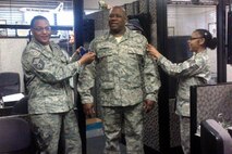 Staff Sgt. James McFadden, center, pins on his new rank as a personnel journeyman assigned to the 916th Force Support Squadron. McFadden recently returned from a deployment supporting the Air Expeditionary Force. (USAF courtesy photo)