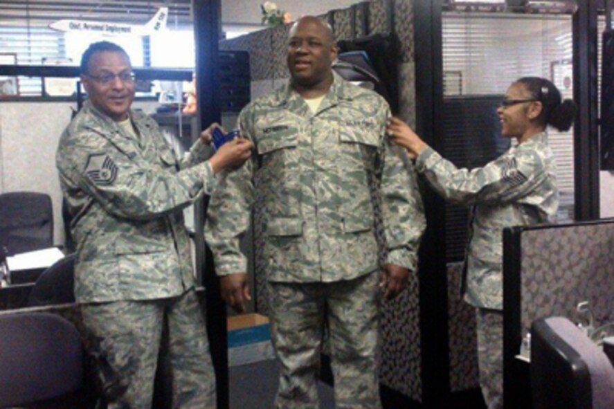 Staff Sgt. James McFadden, center, pins on his new rank as a personnel journeyman assigned to the 916th Force Support Squadron. McFadden recently returned from a deployment supporting the Air Expeditionary Force. (USAF courtesy photo)