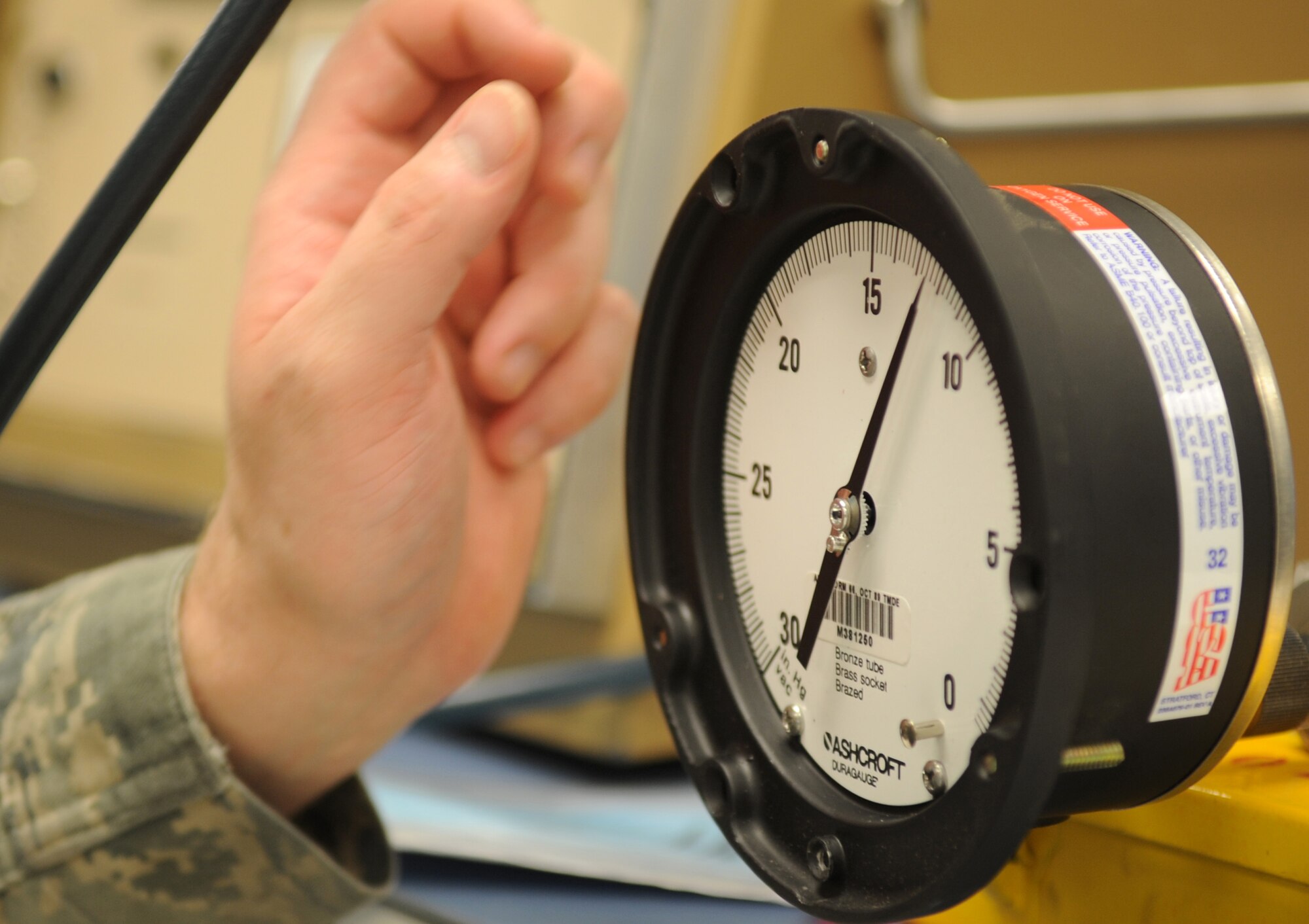 Senior Airman Phillip Henkel, a 19th Component Maintenance Squadron Precision Measurement Equipment Laboratory technician, checks a vacuum gauge for a hydraulic system Aug. 8, 2013, at Little Rock Air Force Base, Ark. PMEL specializes in the calibration of many types of devices and equipment to help keep the base mission-ready. (U.S. Air Force photo by Staff Sgt. Caleb Pierce)