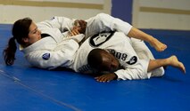 Former 5th Bomb Wing Chief of Public Affairs, Capt. Genieve David, demonstrates Gracie Jiu Jitsu techniques during an instructor certification evaluation. To receive full instructor certification she must demonstrate 15 Gracie Jiu Jitsu techniques, with their variations, in fewer than 10 minutes and score 90 percent or more. The evaluation is conducted via a video evaluation process and uploaded to the Gracie Academy Web site where it is scored. If David succeeds, she will be awarded full instructor certification for the length of two years. David completed the Gracie Jiu Jitsu Women Empowered Probationary Instructor Certification Program in April. (U.S. Air Force photo/Airman 1st Class Kristoffer Kaubisch)