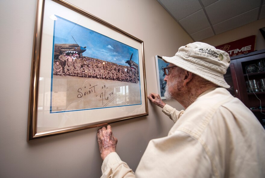 Retired Lt. Col. Harold Stuart, a former 76th Fighter Squadron P-40 Warhawk pilot, looks at a photo of the 76th Fighter Squadron taken during World War II, while visiting Moody Air Force Base, Ga., July 22, 2013. Stuart, now 94 years old, was a P40 pilot credited with one aerial victory during World War II. (U.S. Air Force photo by Senior Airman Jarrod Grammel/Released)
