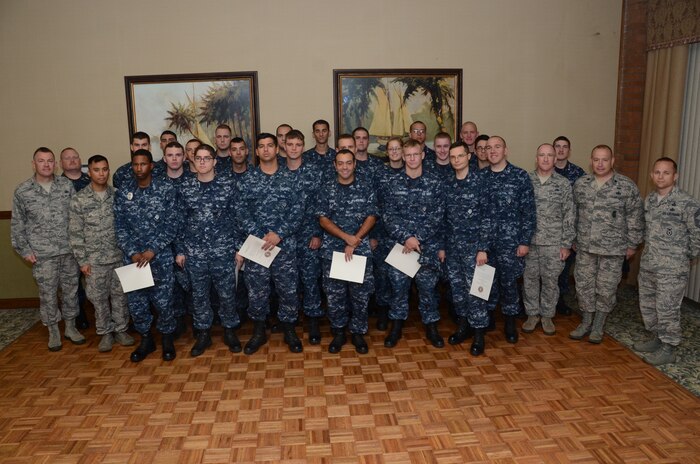 JOINT BASE CHARLESTON - WEAPONS STATION, S.C. — Col. Richard McComb, Joint Base Charleston commander, Master Chief Joseph Gardner Naval Support Activity Charleston command master chief and Chief Master Sgt. Earl Hannon, 628th  Air Base Wing command chief commend  23 members of the auxiliary security force during an all hands call at Storm Pointe Conference Center Aug. 16, 2013 at JB Charleston – Weapons Station, S.C. The 23 Sailors, from Naval Nuclear Power Training Command, augmented the 628th Security Forces Squadron’s ability to provide coverage and control at the gate access points throughout JBC for the past two months. (U.S. Navy photo/ Petty Officer 1st Class Chad Hallford)