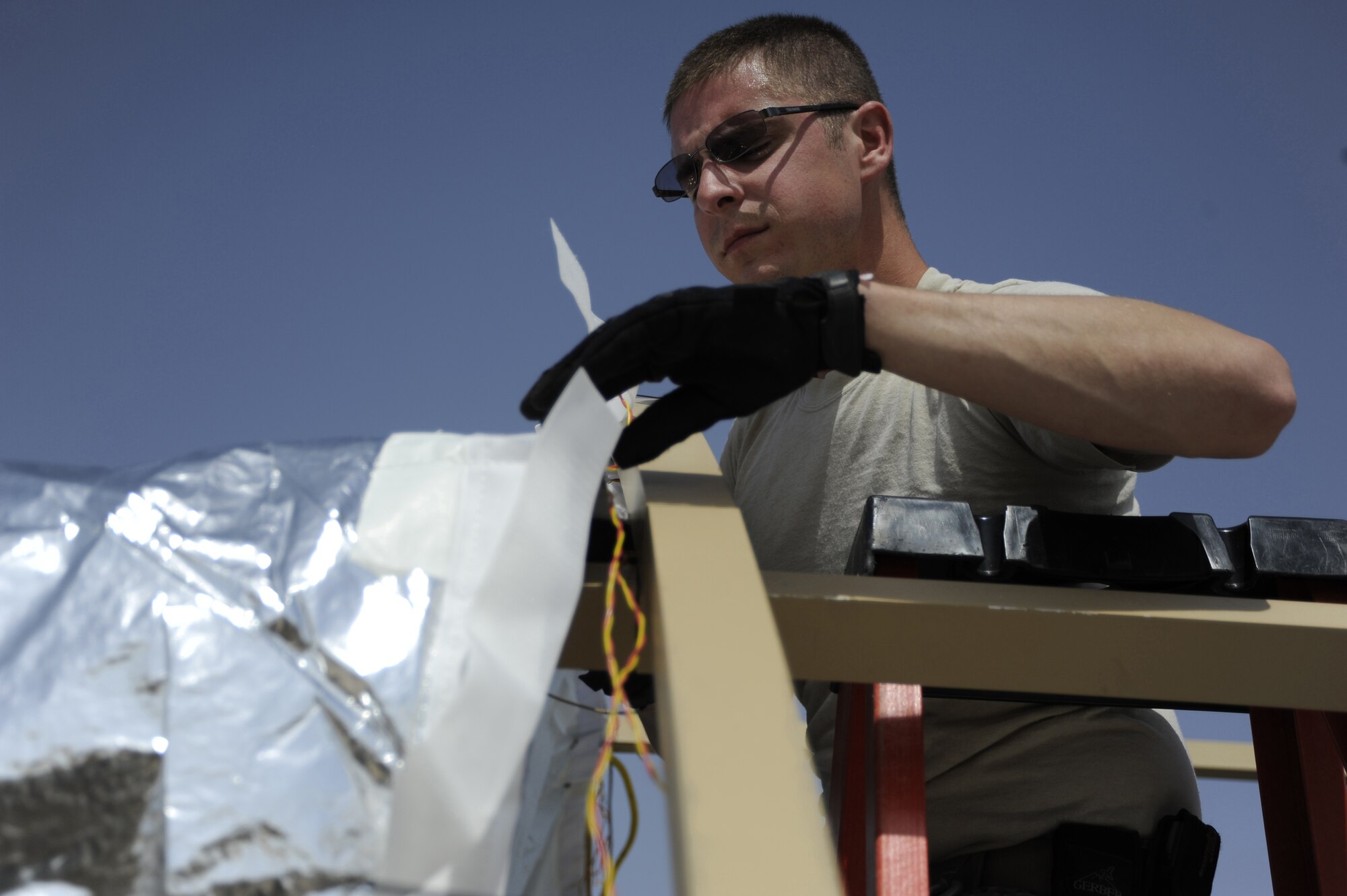 Staff Sgt. Casey Nowicki, 386th Expeditionary Civil Engineer Squadron, structures flight, fastens an insulation cover to the frame of a tent here, Aug. 6, 2013. Nowicki is fastening the insulation portion of the tent before putting the cover on it to help save energy. He is working together with members of the Air Force Civil Engineer Center testing new energy-efficient technologies to reduce the amount of energy for future operations. Nowicki is deployed out of the 110th Airlift Wing, Battle Creek, Mich., Air National Guard unit. (U.S. Air Force photo by Master Sgt. Christopher A. Campbell)