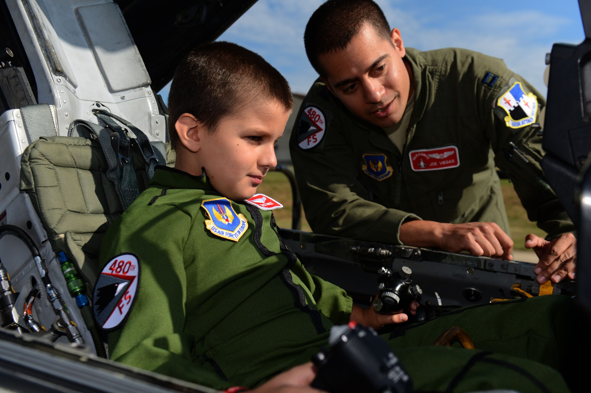 SPANGDAHLEM AIR BASE, Germany – U.S. Air Force Capt. Joseph Viegas, 480th Fighter Squadron pilot from Minneapolis, shows Stevie Frost, 9, the inside of an F-16 Fighting Falcon fighter Aircraft Aug. 16, 2013. Stevie spent 14 months in and out of a local German hospital undergoing chemotherapy and radiation treatments and is now 100 percent cancer free. (U.S. Air Force photo by Airman 1st Class Gustavo Castillo/Released) 