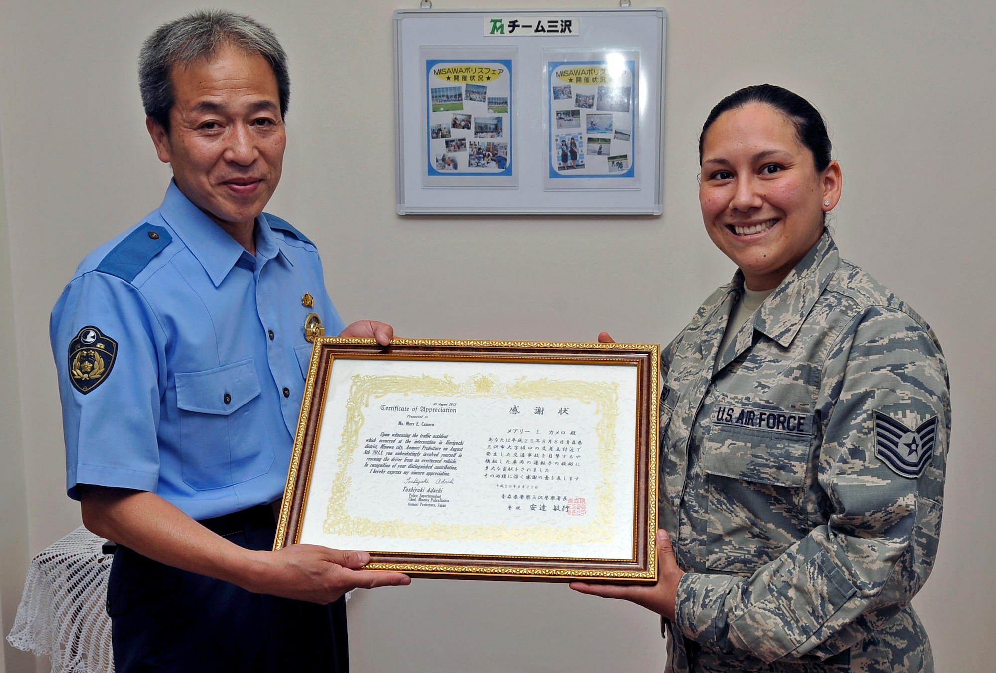 Toshiyuki Adachi, chief of the Misawa Police Station, presents a certificate of appreciation to U.S. Air Force Tech. Sgt. Mary Camero, 35th Logistics Readiness Squadron customer support supervisor, in Misawa City, Japan, Aug. 21, 2013. Camero was recognized for her actions in response to an Aug. 8, 2013 car accident where she rescued a trapped driver from an overturned vehicle. (U.S. Air Force photo by Airman 1st Class Zachary Kee)