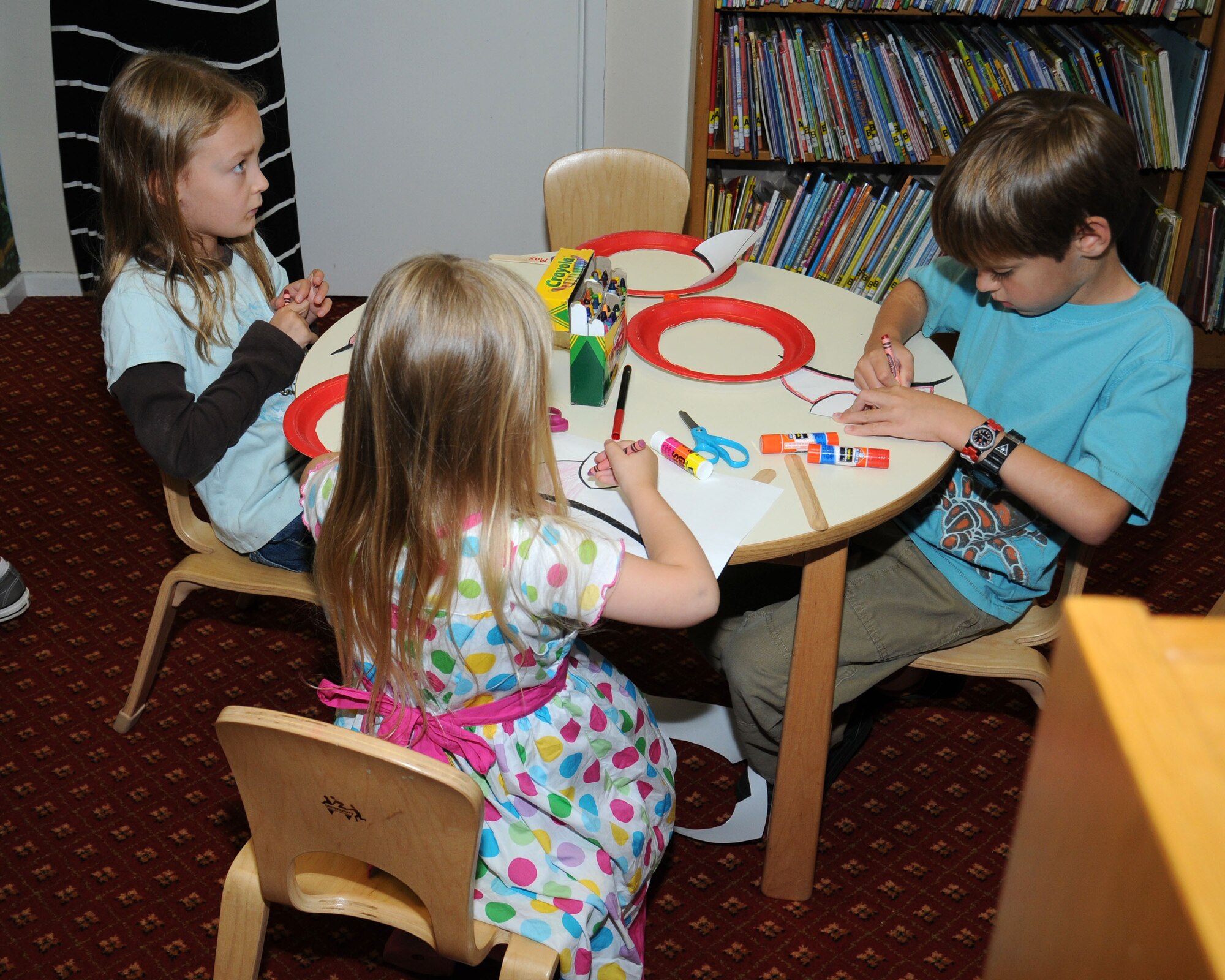 Team Mildenhall children make a fireman’s mask during an arts and craft session following a book reading Aug. 21, 2013, at the library on RAF Mildenhall, England. The children were given the chance to speak to firefighters and sit in a fire truck. The firefighters taught the children firefighters are to be trusted and not feared. (U.S. Air Force photo by Gina Randall/Released)