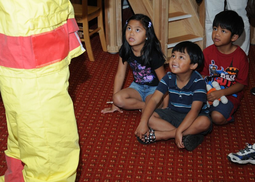 Team Mildenhall children interact with “Sparky,” 100th Civil Engineer Squadron Fire Department mascot, Aug. 21, 2013, at the library on RAF Mildenhall, England. More than 20 children came to see Sparky and the firefighters read fire safety-themed stories. The children also took part in an arts and crafts session. (U.S. Air Force photo by Gina Randall/Released)