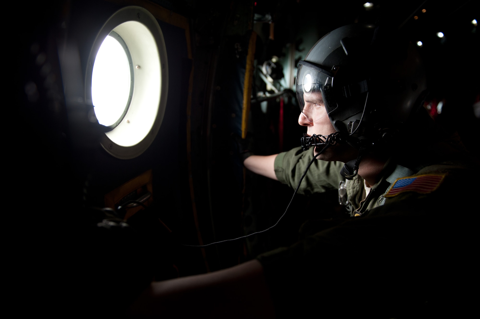 A loadmaster waits to open a side door for U.S. Army Soldiers Aug. 22, 2013, during jump training over Yokota Air Base, Japan. The loadmaster is assigned to the 36th Airlift Squadron. (U.S. Air Force photo by Senior Airman Cody H. Ramirez)